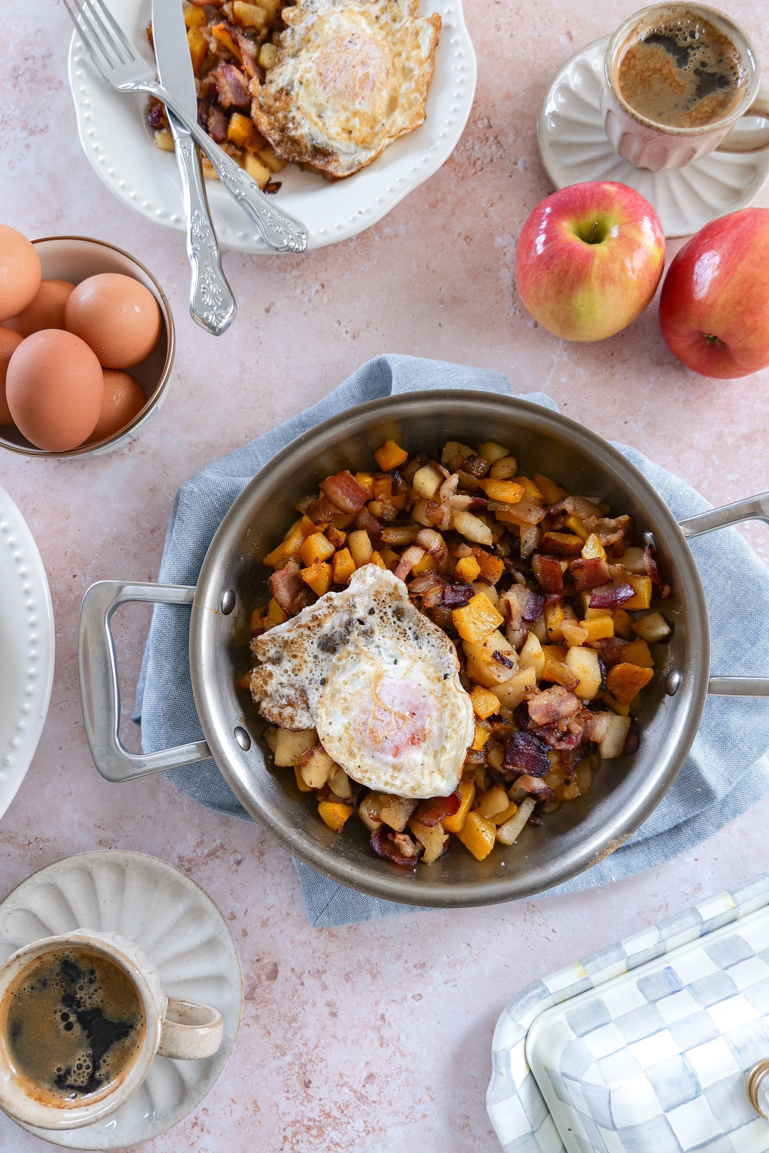 Breakfast hash with golden roasted butternut squash, bacon, apples, onions, and eggs.
