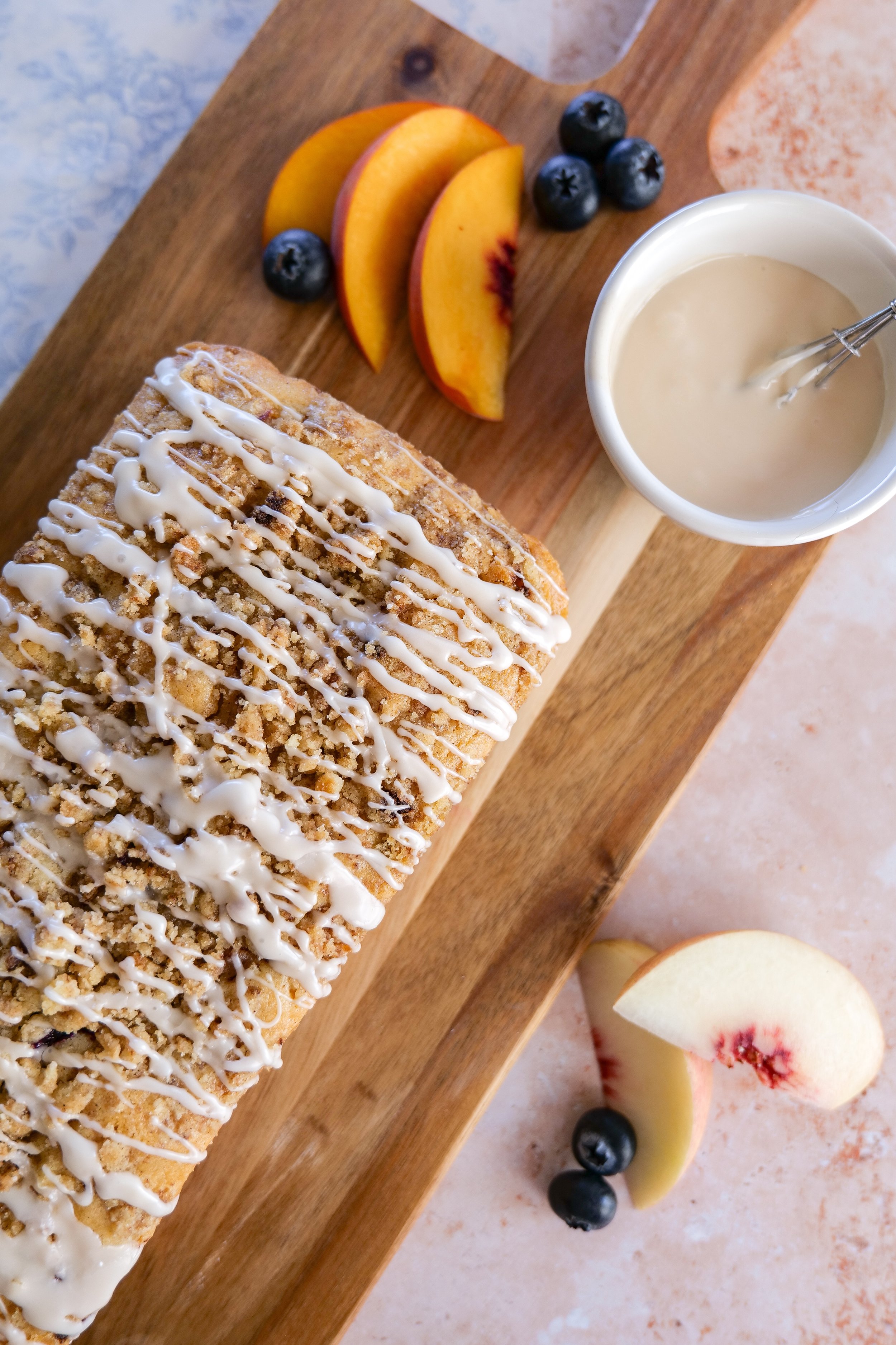 Slices of homemade Blueberry Peach Bread showing fresh peaches, blueberries, and cinnamon streusel inside.