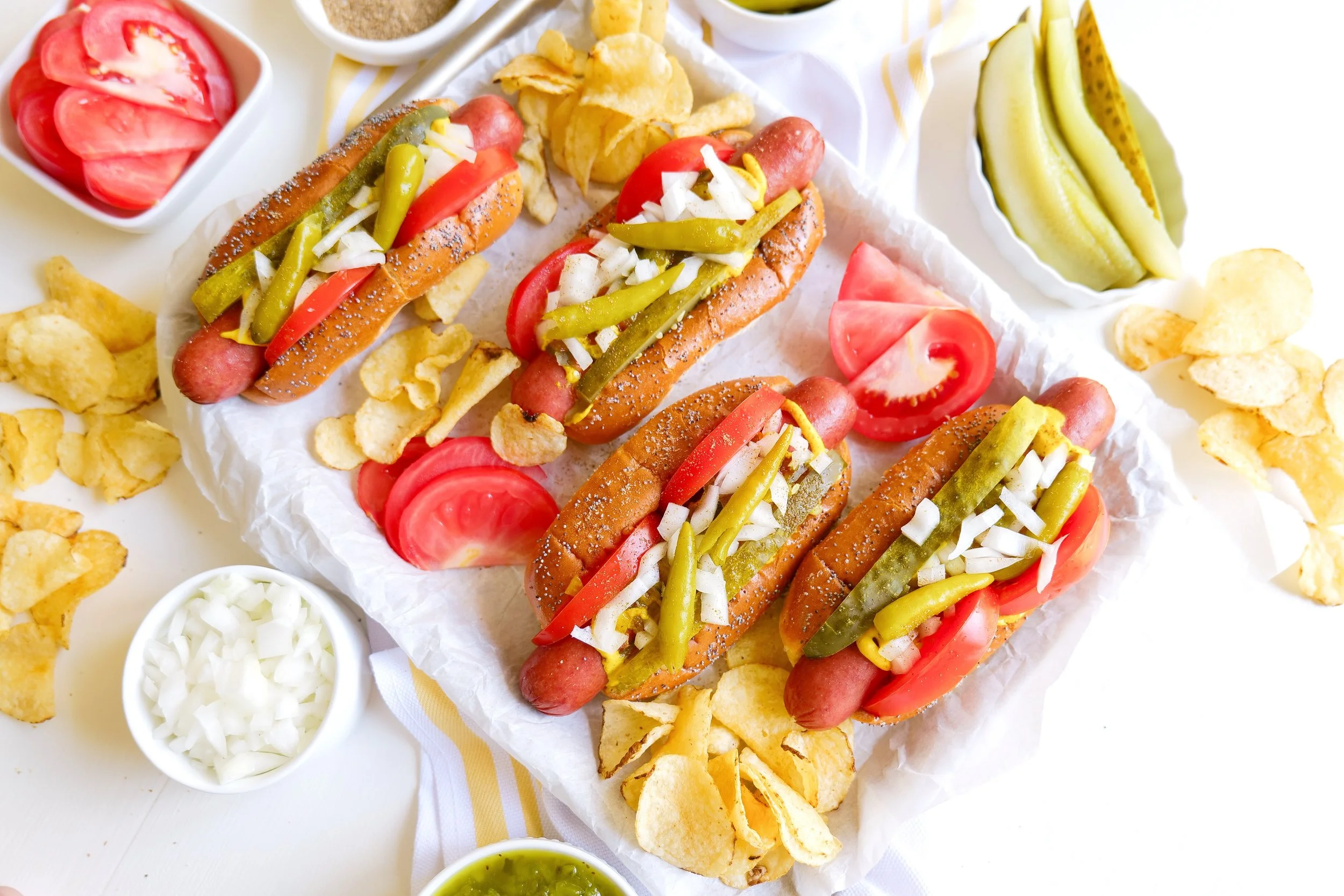 Chicago hot dog toppings arranged on a freshly grilled hot dog in a poppy seed bun.