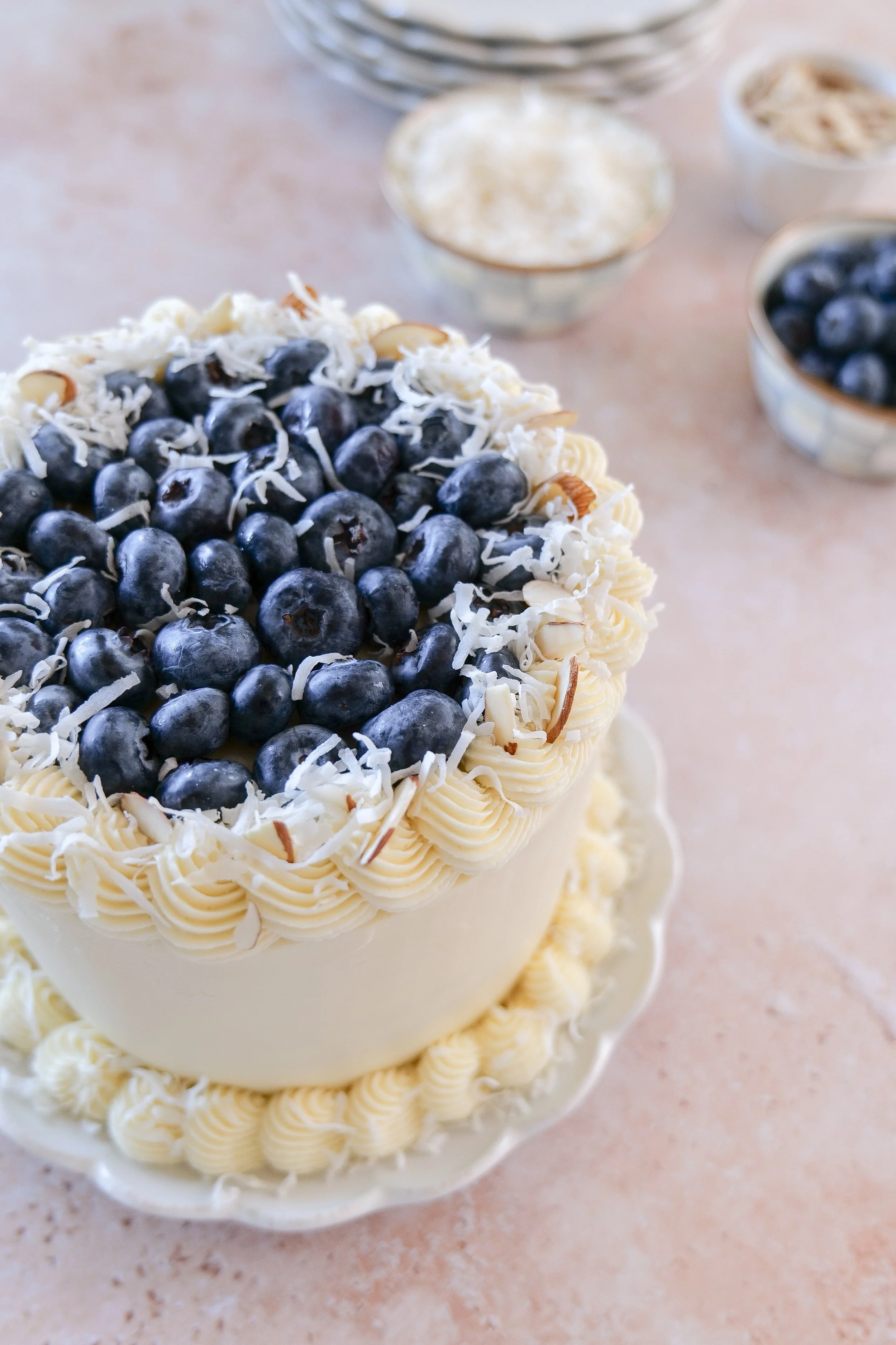Coconut frosted cake decorated with fresh blueberries.