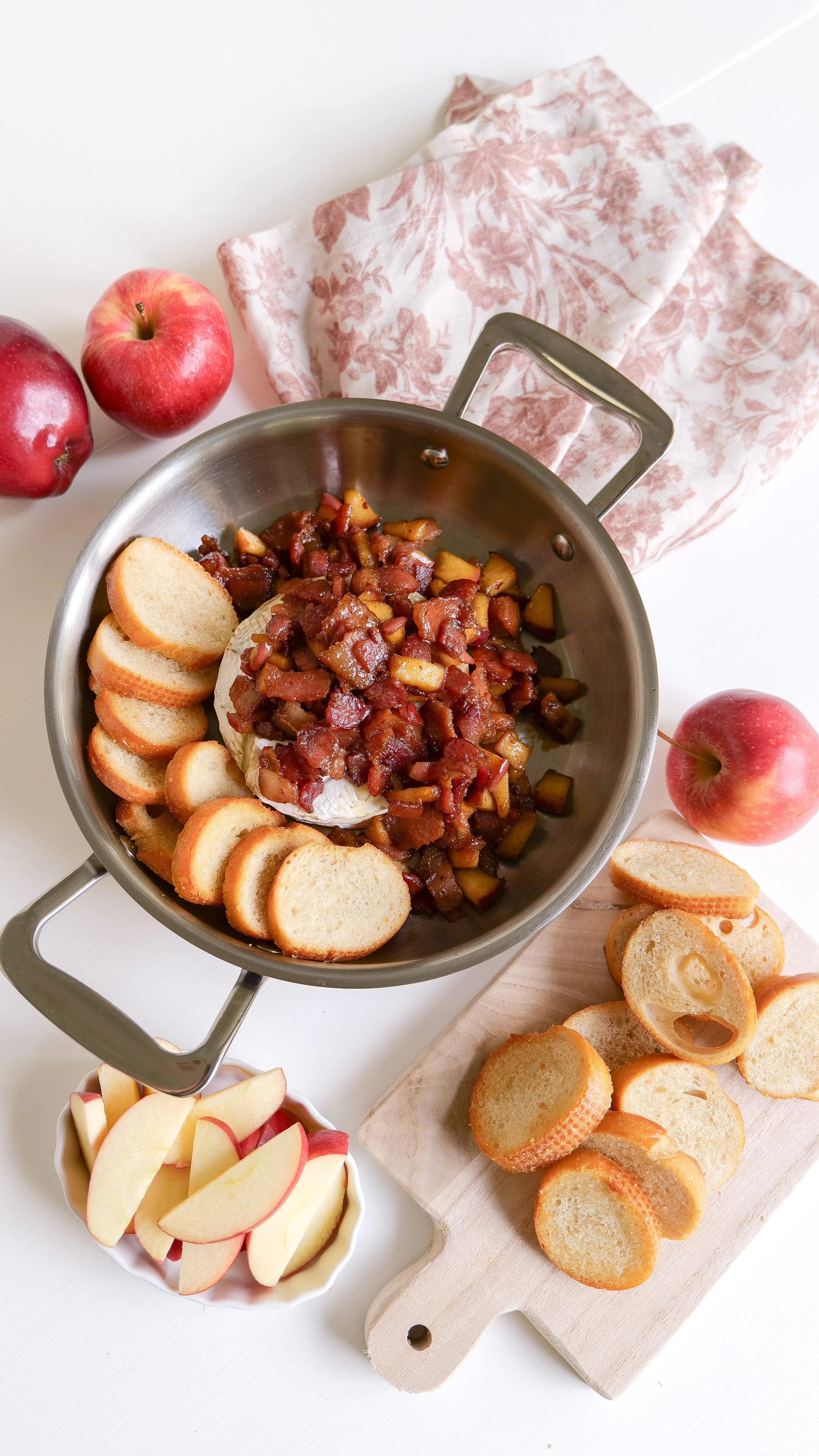 Warm baked brie with apples and bacon served for a Thanksgiving appetizer.