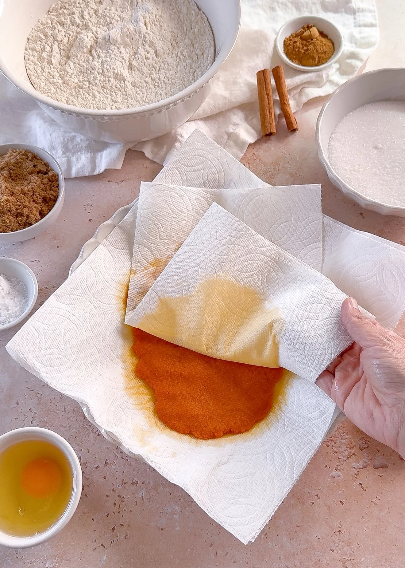Pumpkin puree being blotted to remove excess moisture for pumpkin cutout cookies
