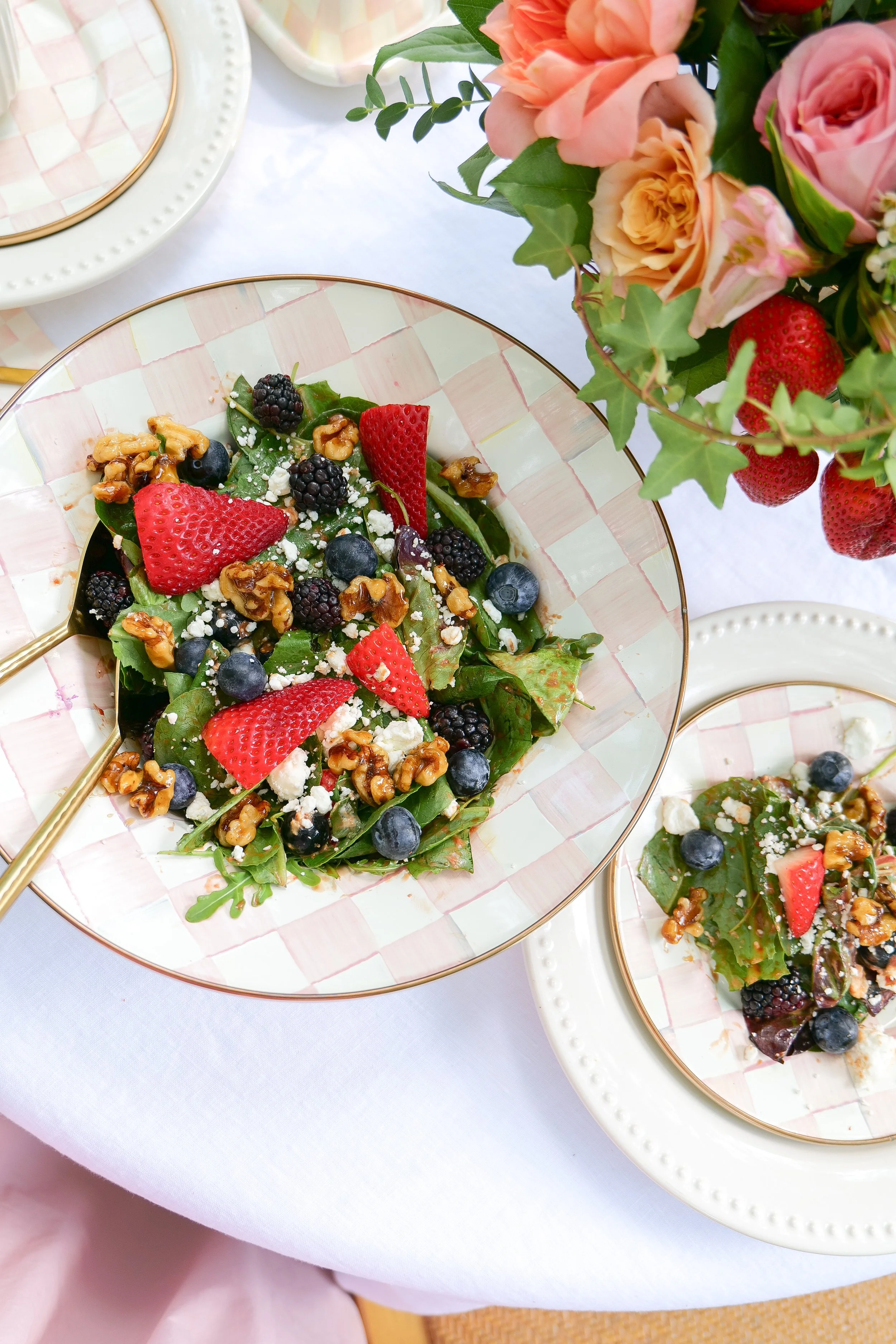 Spinach salad topped with fresh strawberries, blueberries, blackberries, goat cheese and candied walnuts.