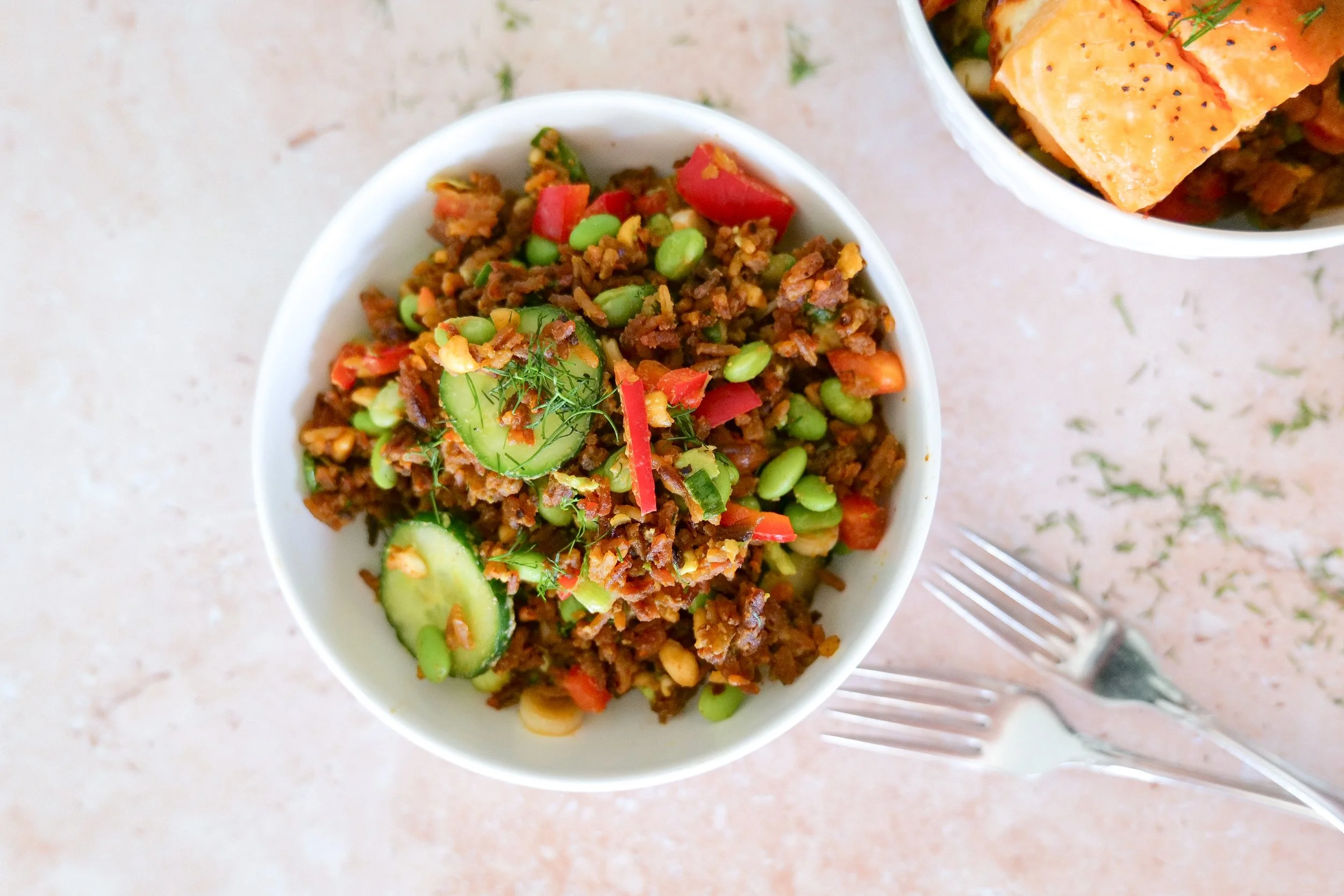 Crispy rice salad with fresh vegetables, salmon and creamy peanut-chili dressing.