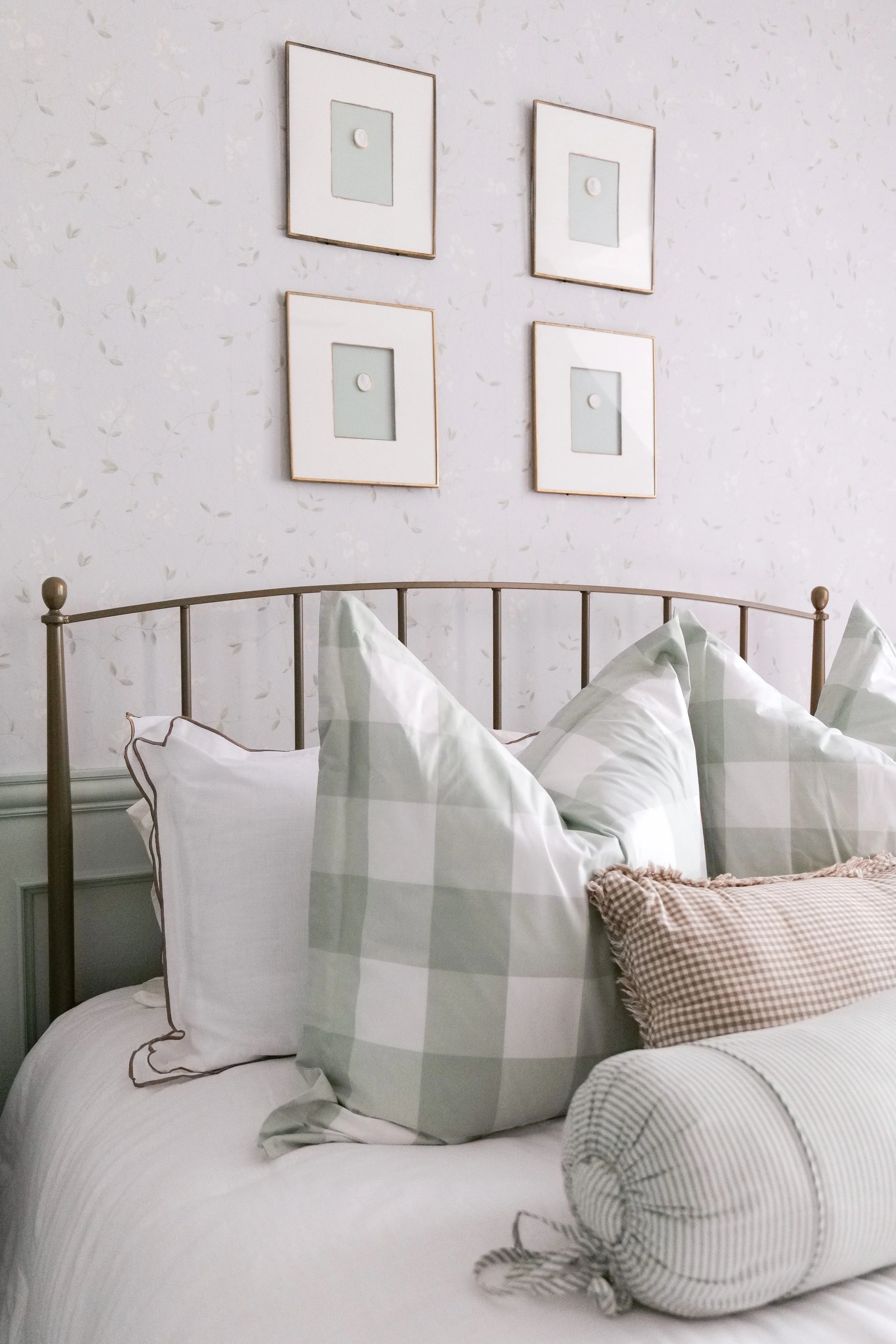 Cozy traditional guest bedroom bed styled with soft blue bedding and neutral layers.