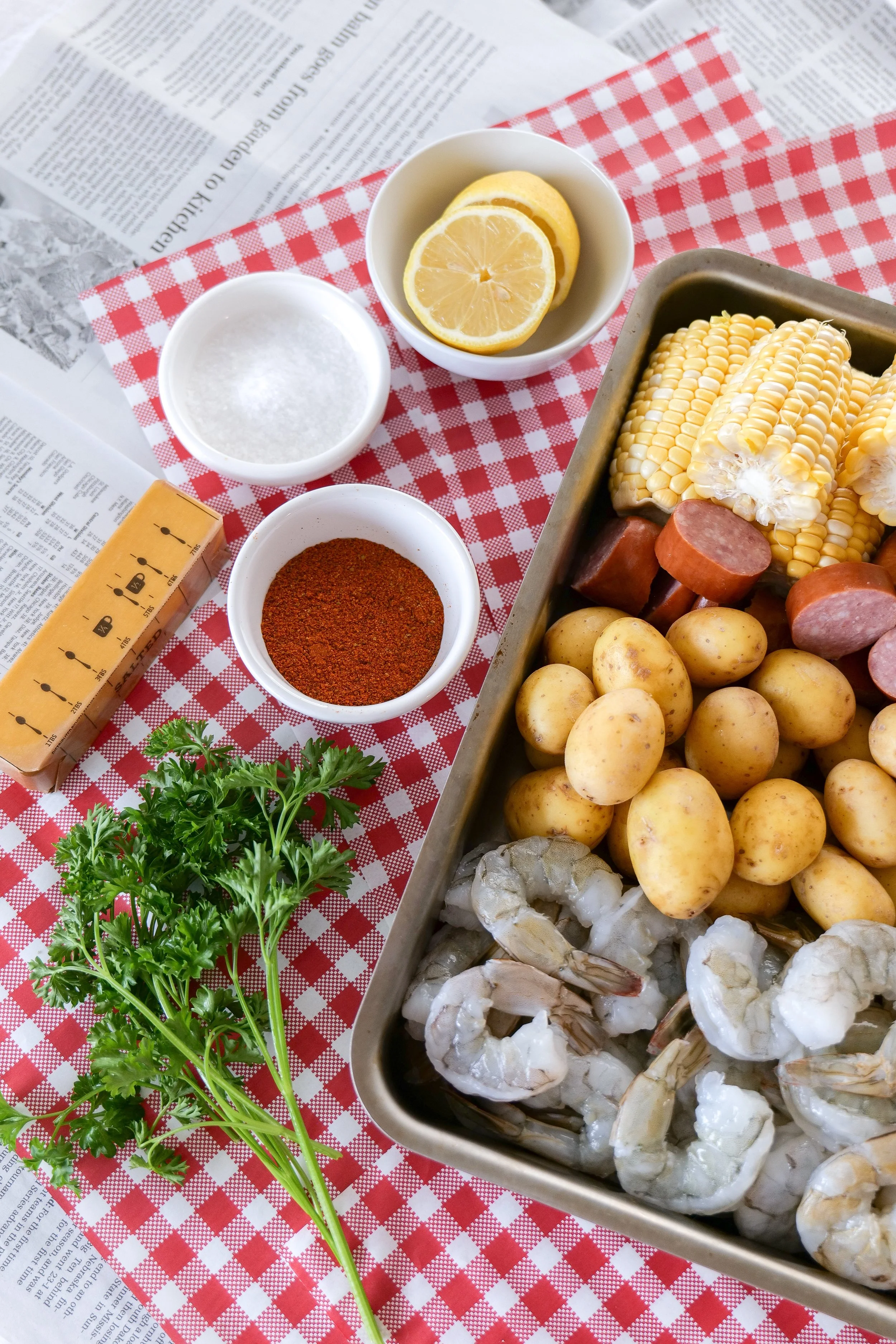 Large serving platter filled with shrimp boil ingredients for a summer gathering.