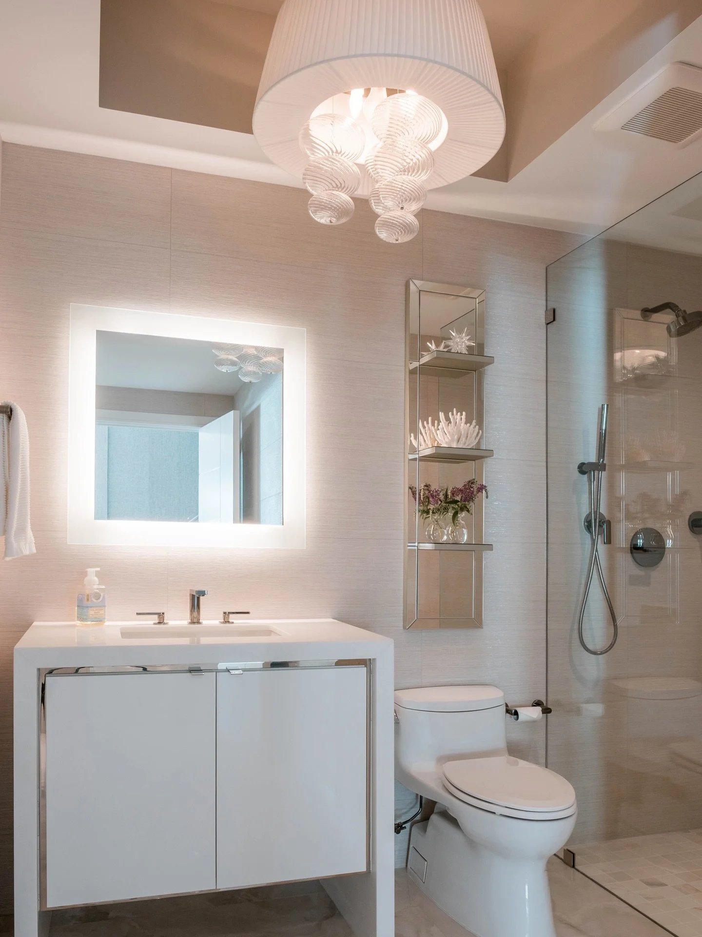 Soft glow, clean lines, and just the right touch of sparkle ✨ This bathroom blends warmth and modern elegance from the sculptural lighting to the layered textures and airy glass details. A little moment of everyday luxury 🤍🛁