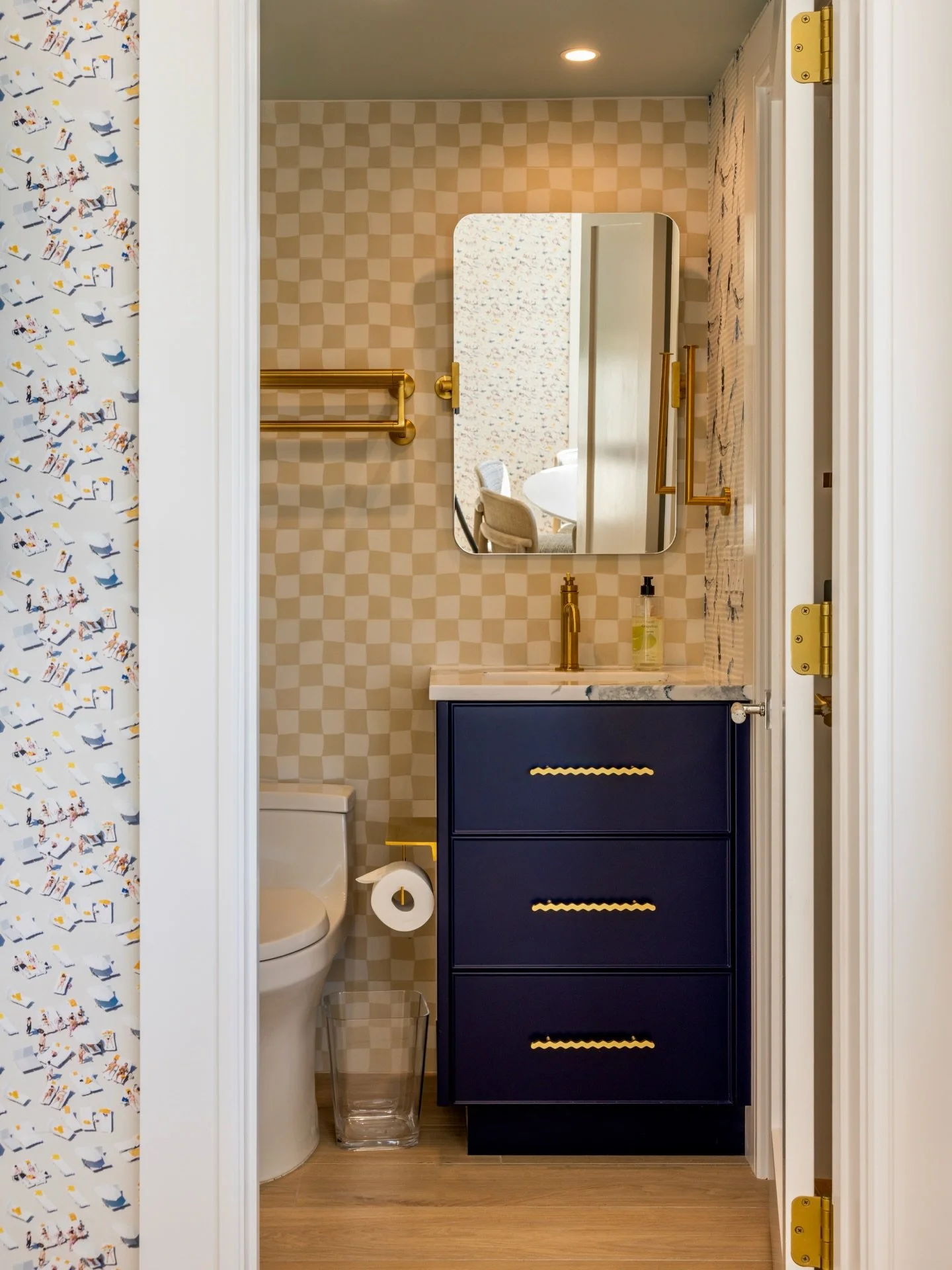 This bathroom was all about pattern play ✨ from the checkerboard tile walls to the graphic diver wallpaper, every detail was designed to feel layered, playful, and a little unexpected. Grounded by a rich navy vanity and warm brass accents, it&rsquo;s