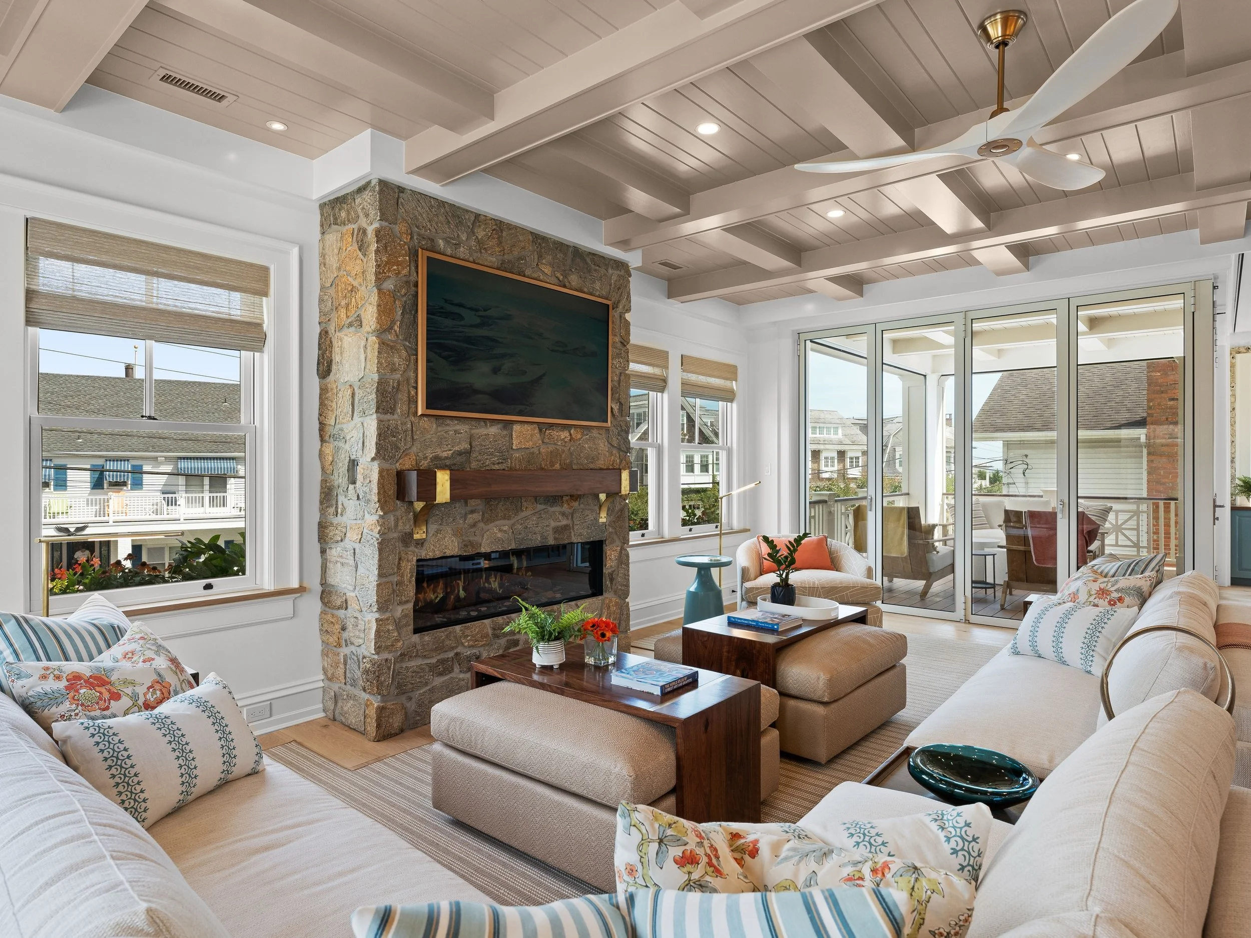Elevated coastal comfort 🤍 Layered textures, soft neutrals, and a statement stone fireplace create a space that feels both relaxed and refined. From the coffered ceiling to the sun-filled seating, every detail is designed for easy, effortless living