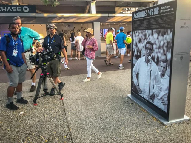 An ESPN crew tapes some of the imagery. Shots of the exhibition were used throughout the US Open broadcasts.