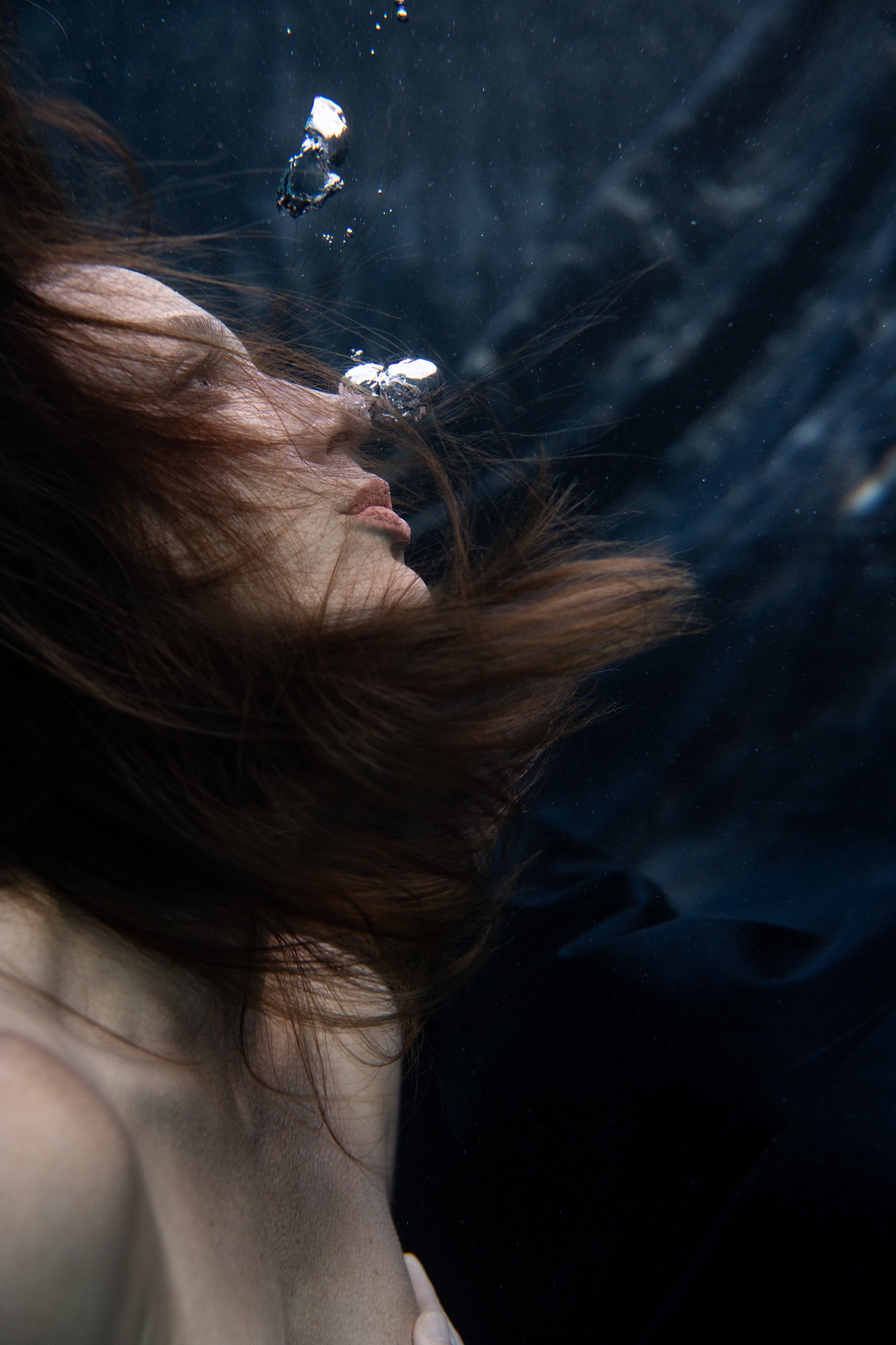 Underwater close-up portrait with floating hair and air bubbles