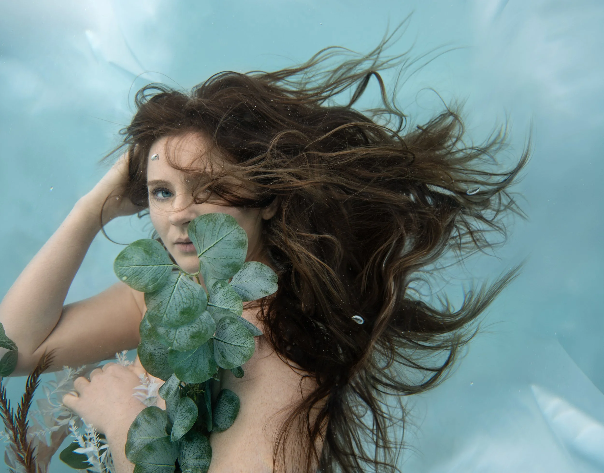 Underwater botanical portrait with flowing hair and soft natural light