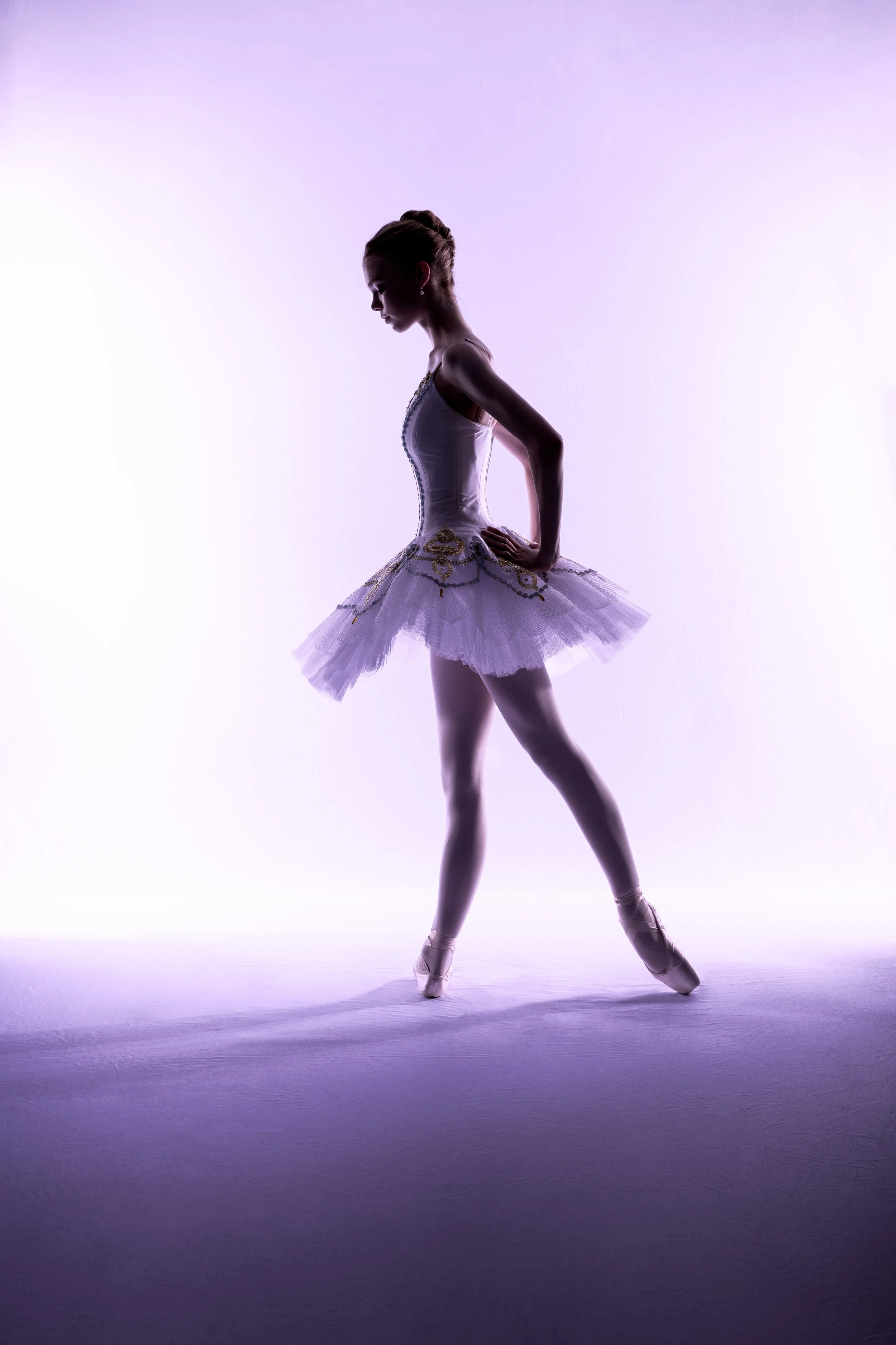 Ballet silhouette portrait with soft purple light and classical pose
