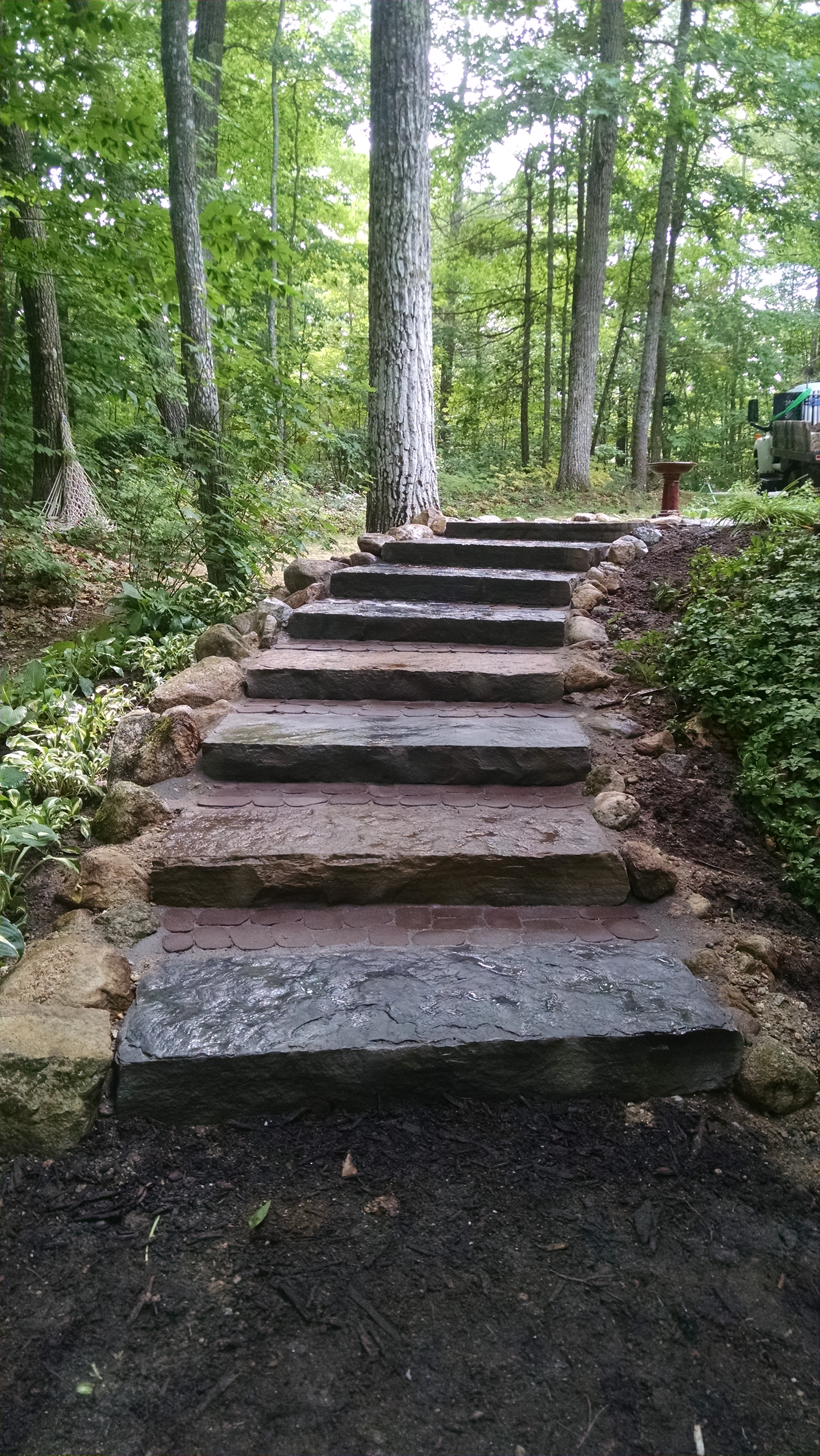 A highly erosive, worn-out path to LIttle Sebago Lake in Gray, Maine, was transformed into a functional, non-eroding, safe and durable staircase using natural stone steps reinforced with rocks and shade-tolerant ground-cover vegetation. PHOTO: Bourne Landscaping