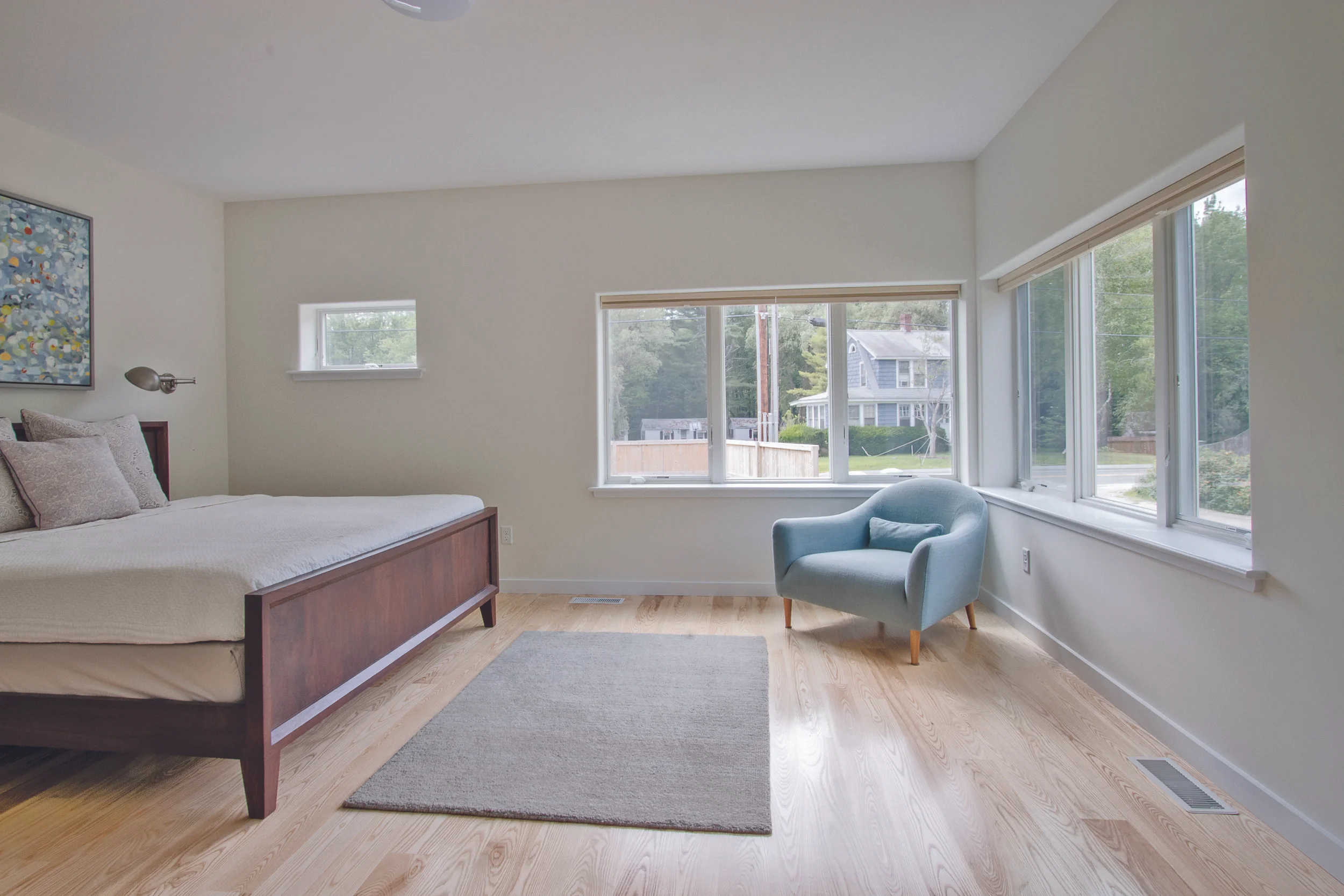 The master bedroom is punctuated by large corner windows and local ash flooring, making the space warm and welcoming.