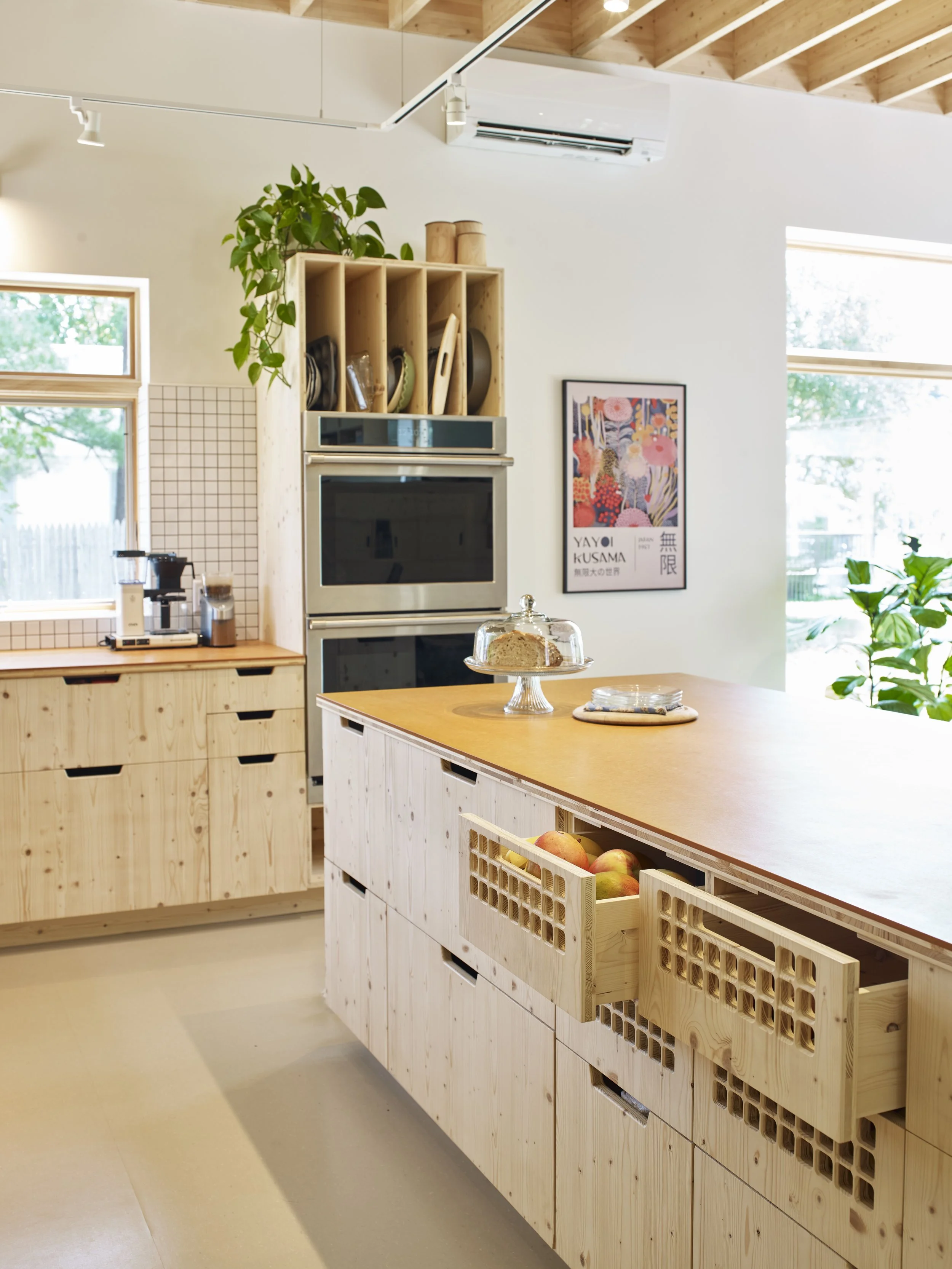 Functionality comes first in the comfortable, bright, all-electric kitchen and dining area, which includes an induction cooktop, a two-drawer dishwasher, and a mixture of open and closed shelving. Din's thoughtful design and labor-of-love cabinetry