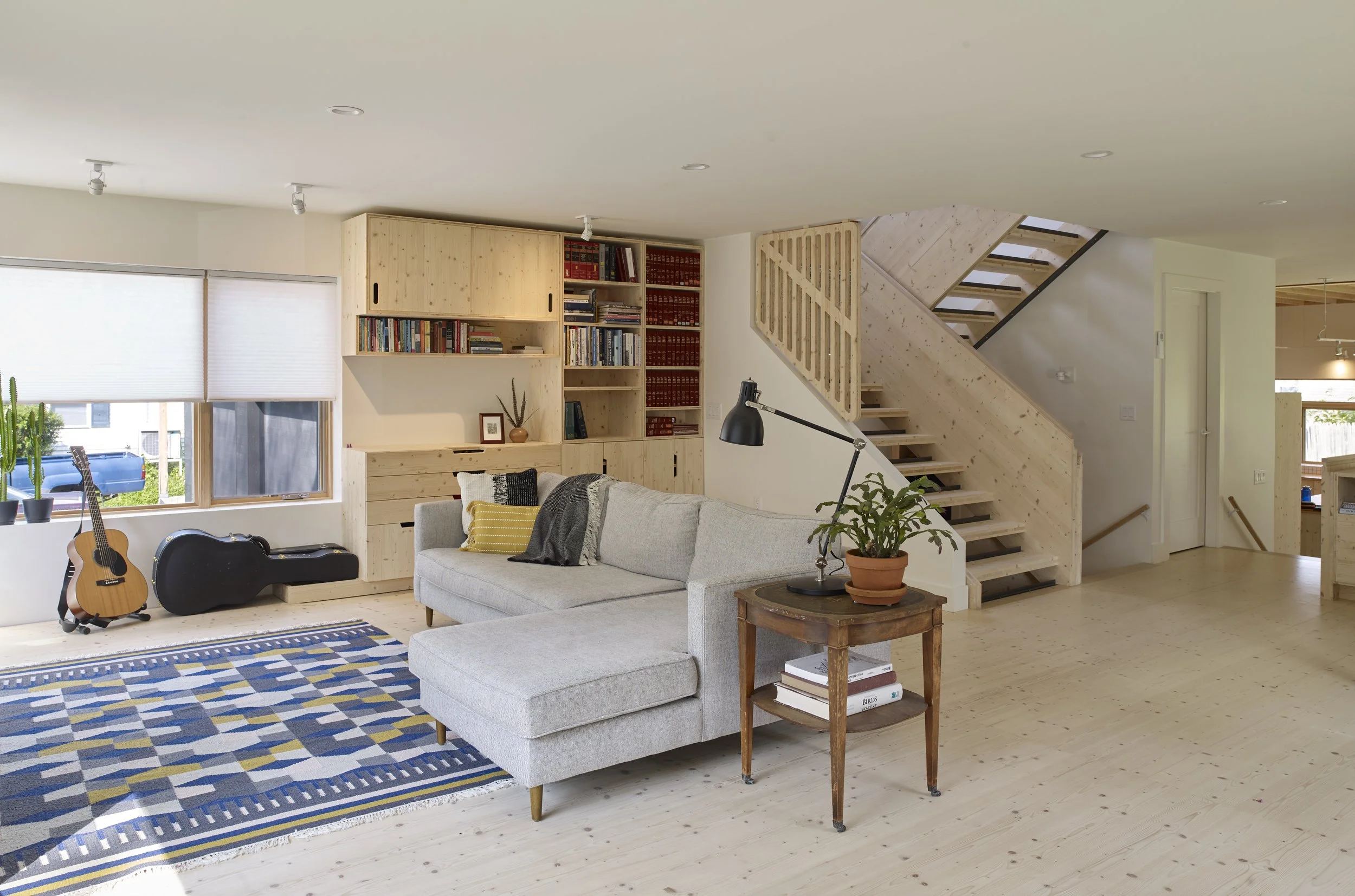 Light pours into the living area from all sides and is echoed by the pale flooring. "Softwood (spruce) floors and cabinetry were a bit of a risk with two kids and a dog," Din says, "and though things are dinged and gouged, we don't mind, and it sti