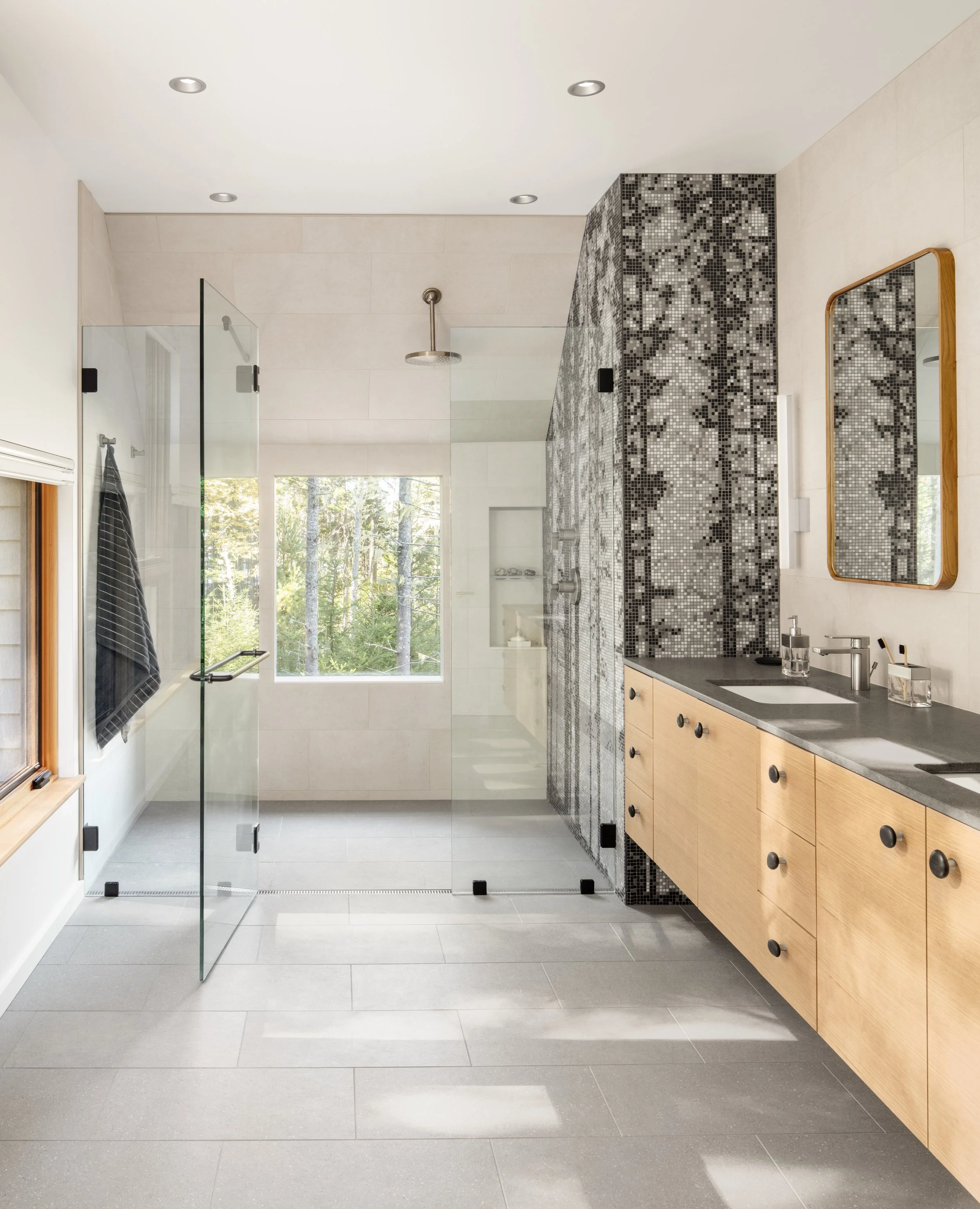  The primary bath features a large walk-in shower, featuring a custom black-and-white mosaic based on a photograph of Squid Cove's setting itself. Ample cabinet space ensures counters remain clutter-free. 