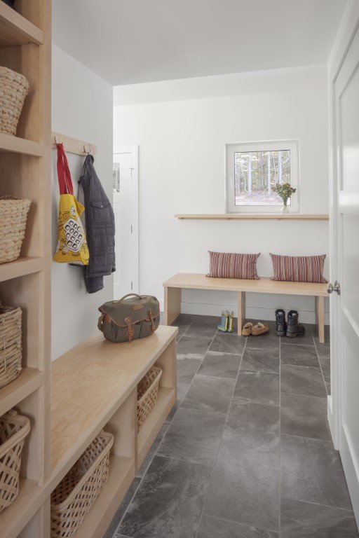 A mudroom as beautiful as it is practical, with storage, places to sit while wrestling with footgear and a floor that can take whatever you throw at—or on—it.
