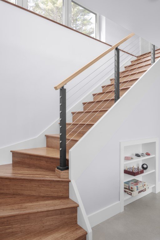 A lovely, open wooden staircase connects the main living area upstairs to the family room below.