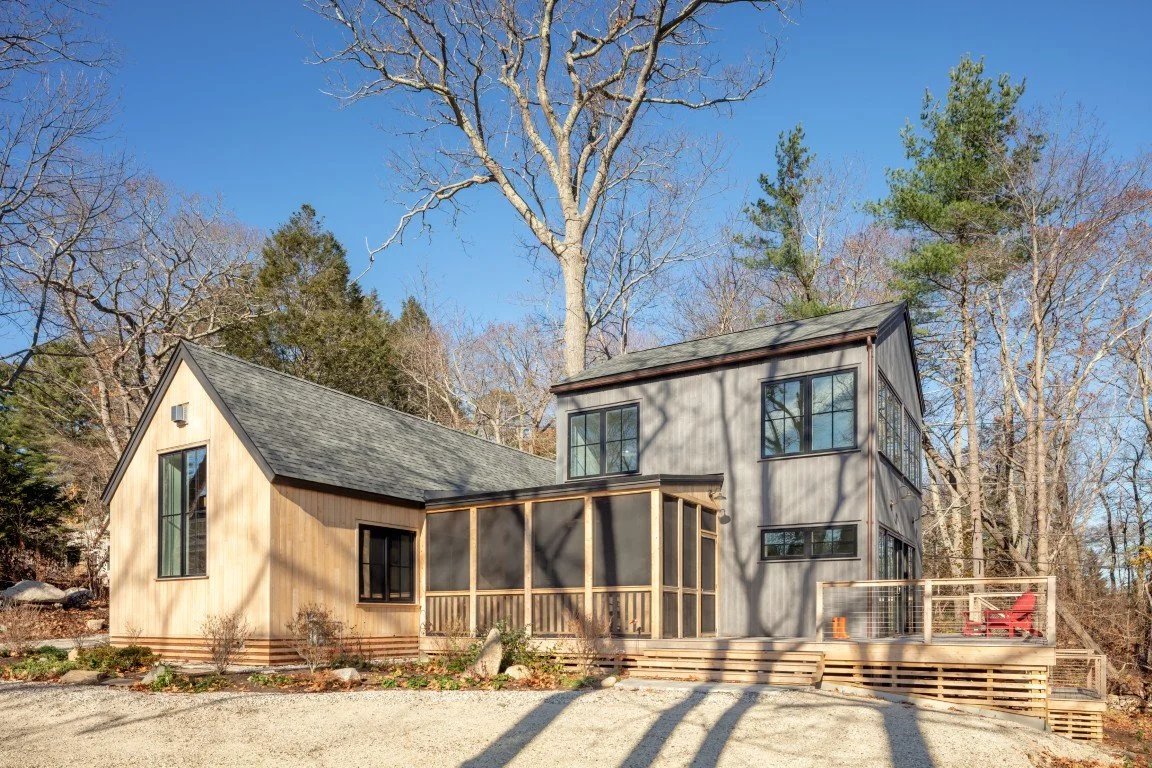 Grey and brown cedar home surrounded by leafless trees