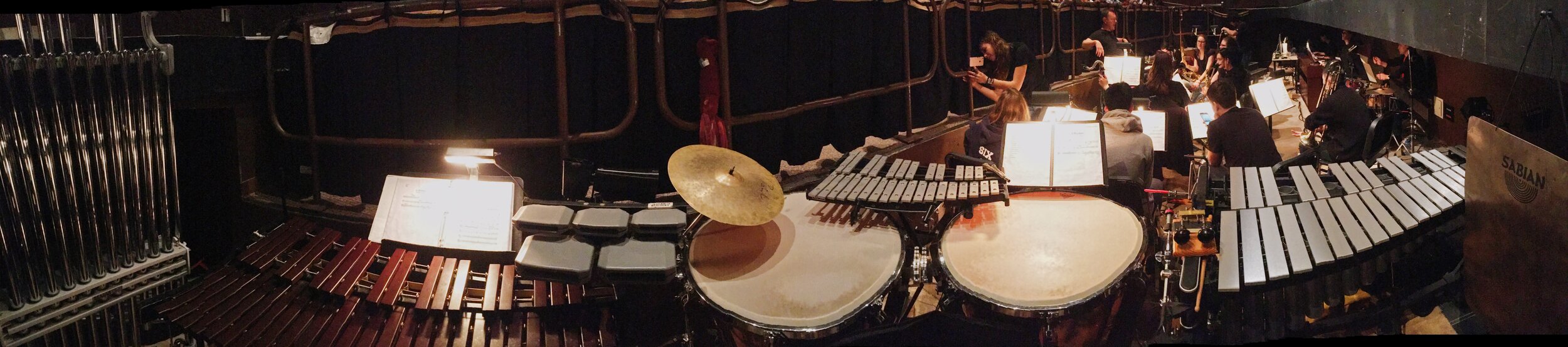The percussion setup (pictured: tubular bells, xylophone, temple blocks, cowbells, suspended cymbal, timpani, glockenspiel, honk horn, triangle on Miller Machine, castanets, thunder sheet. not pictured: bass drum, vibraslap, bell tree, anvil, wood b…