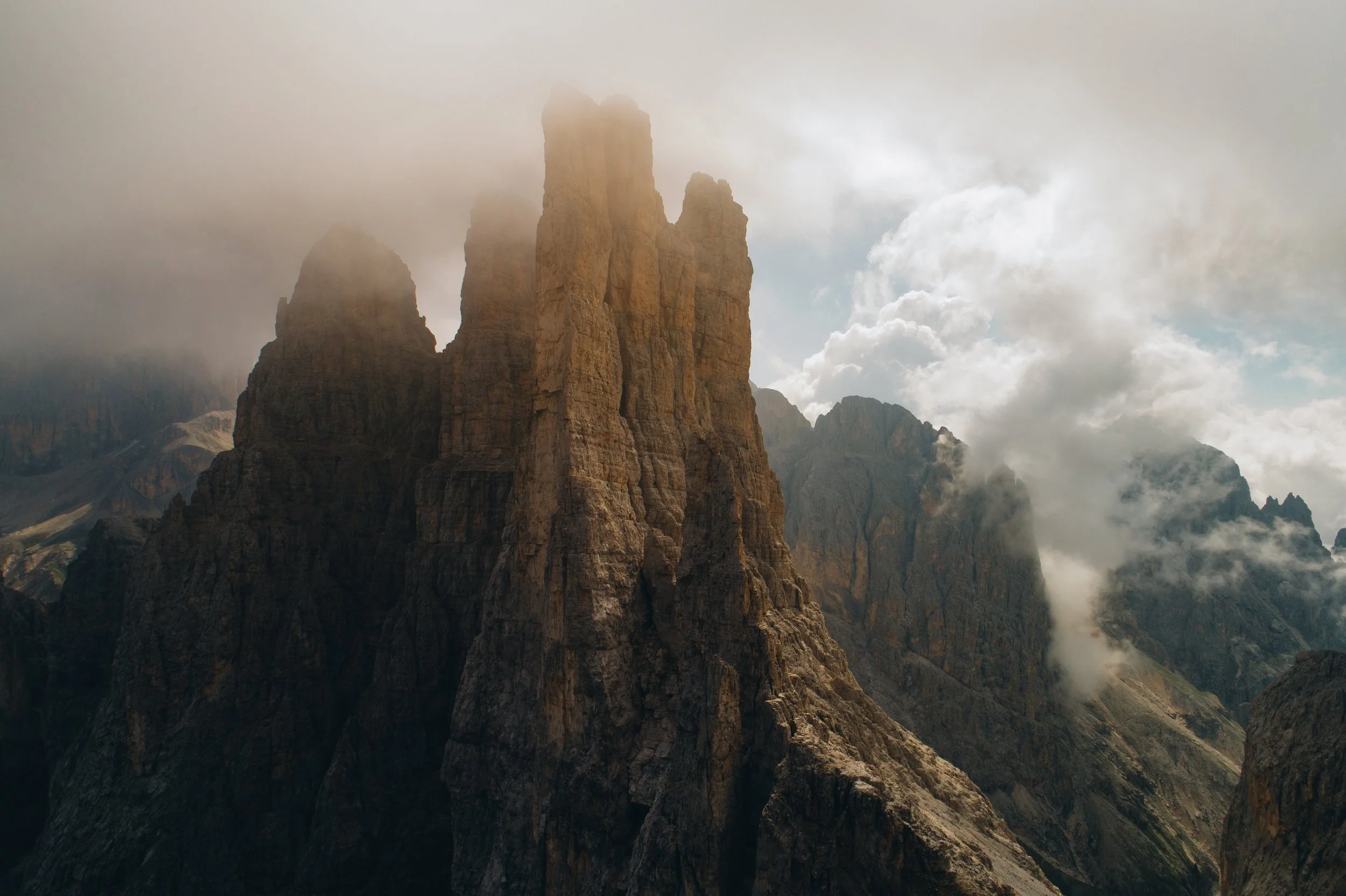 Aerial view of rugged coastline with cliffs on the right and the ocean on the left, during sunset or sunrise.