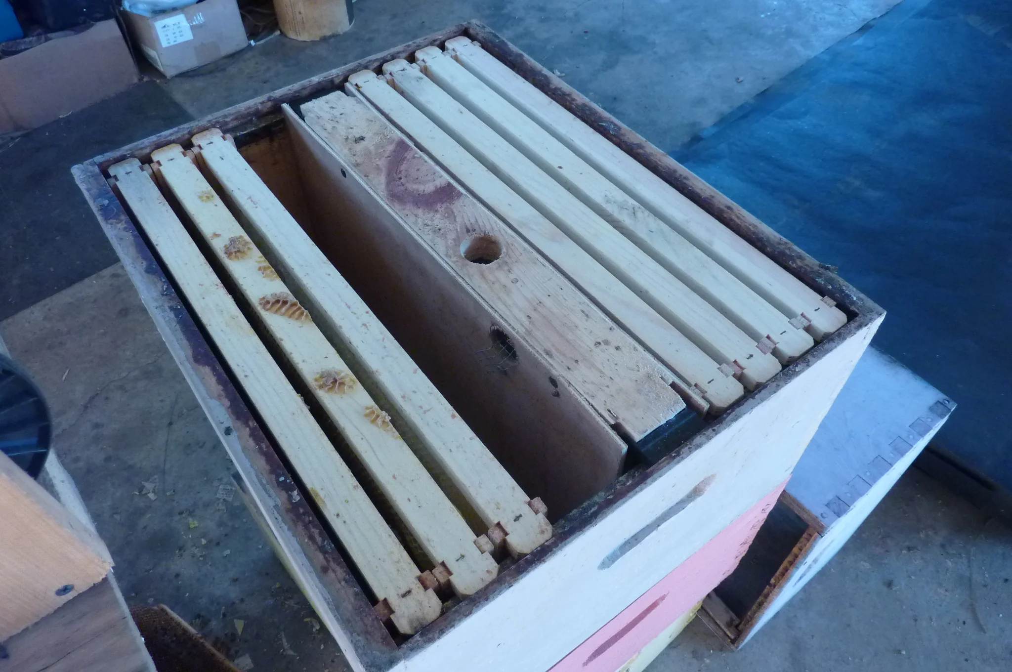  Double hive frame feeder. This is a experiment. This past year did not work very well because queens crossed over through feeder and one killed the other. Putting on queen excluders through feeder holes.  