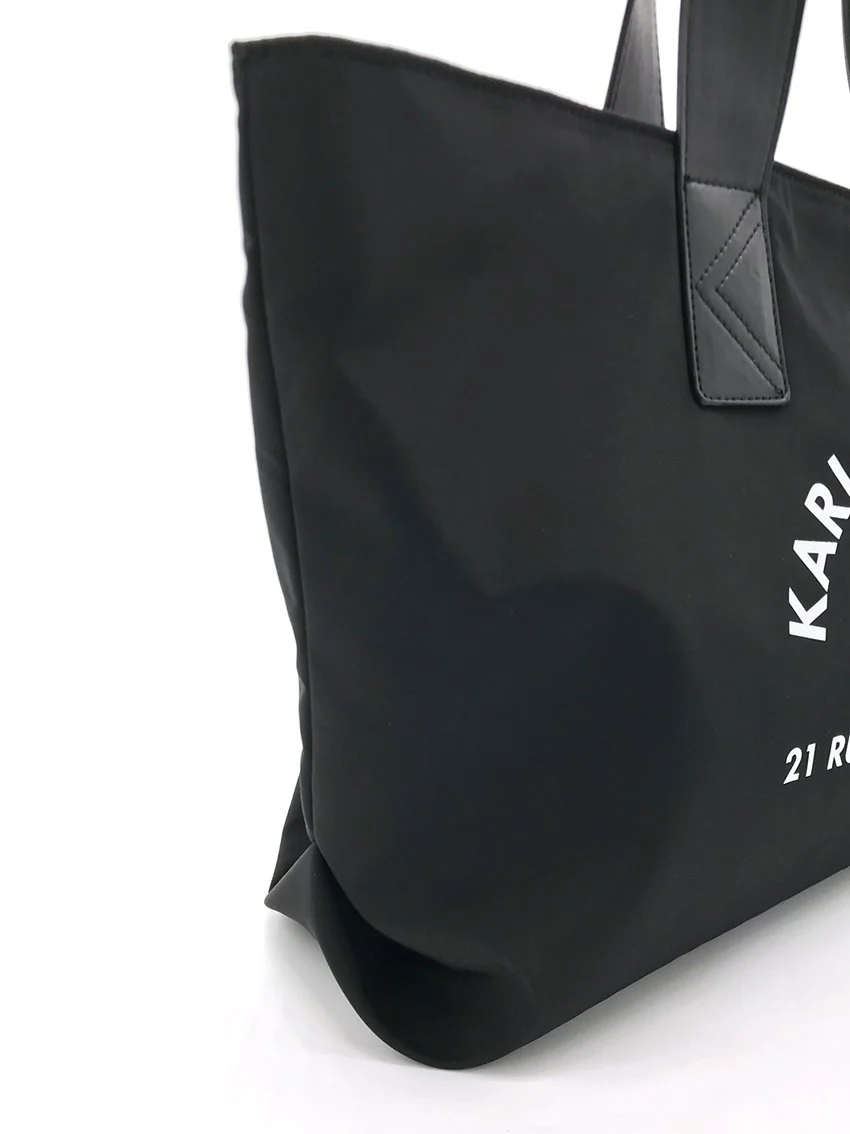  Side construction detail of a tote bag made with nylon and vegan leather as main materials.  Made for  CWF© (Karl Lagerfeld Kids®)  