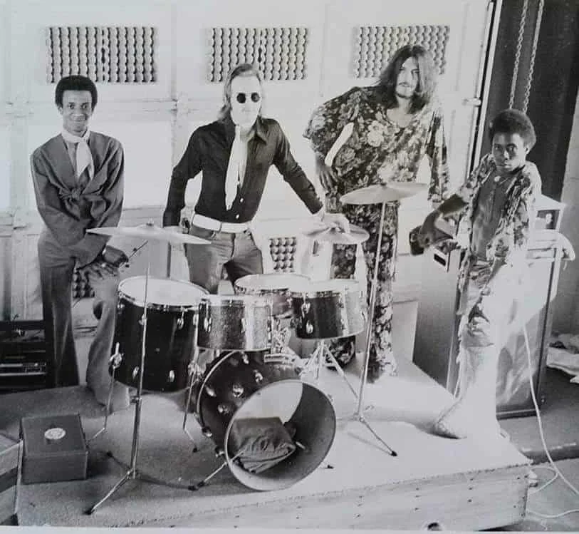 Photo of a band from the 1970s posing with a drumset.