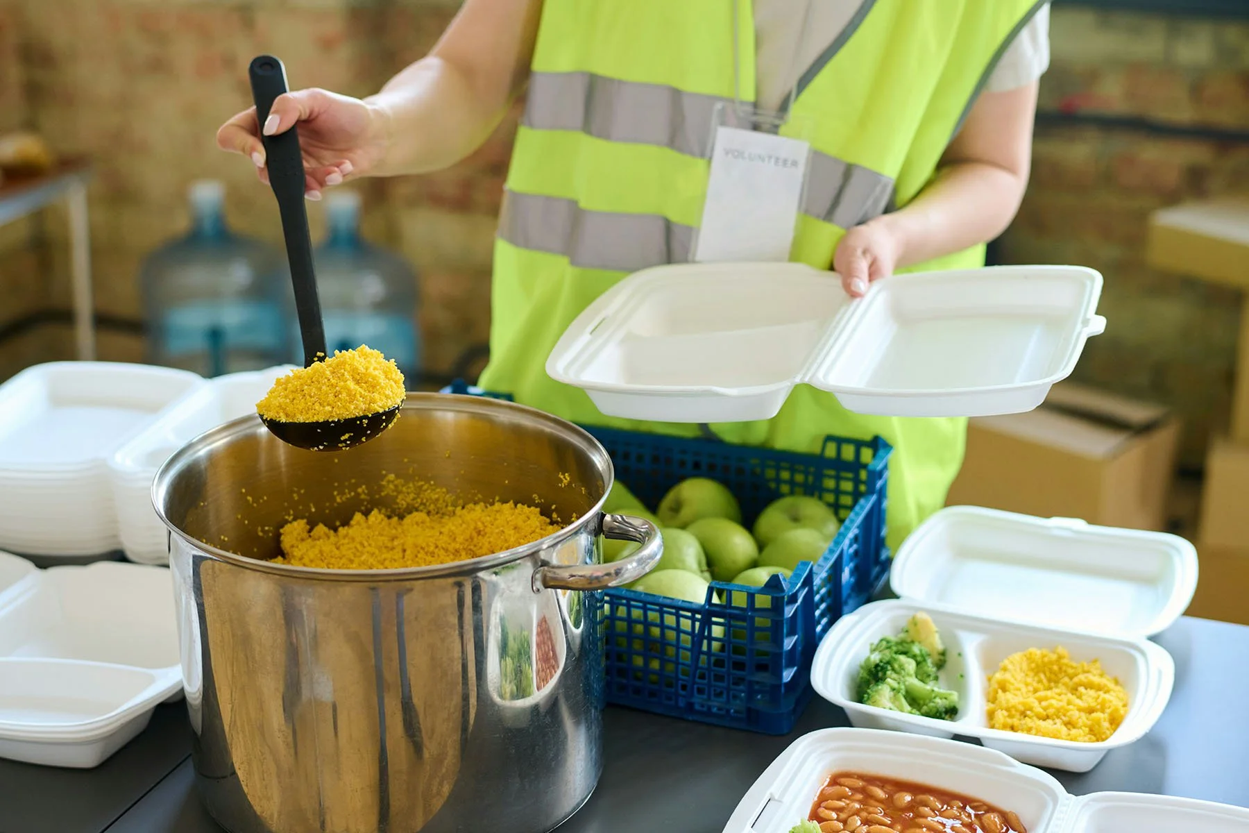 Volunteer preparing hot meals for people experiencing homelessness during a community outreach event.