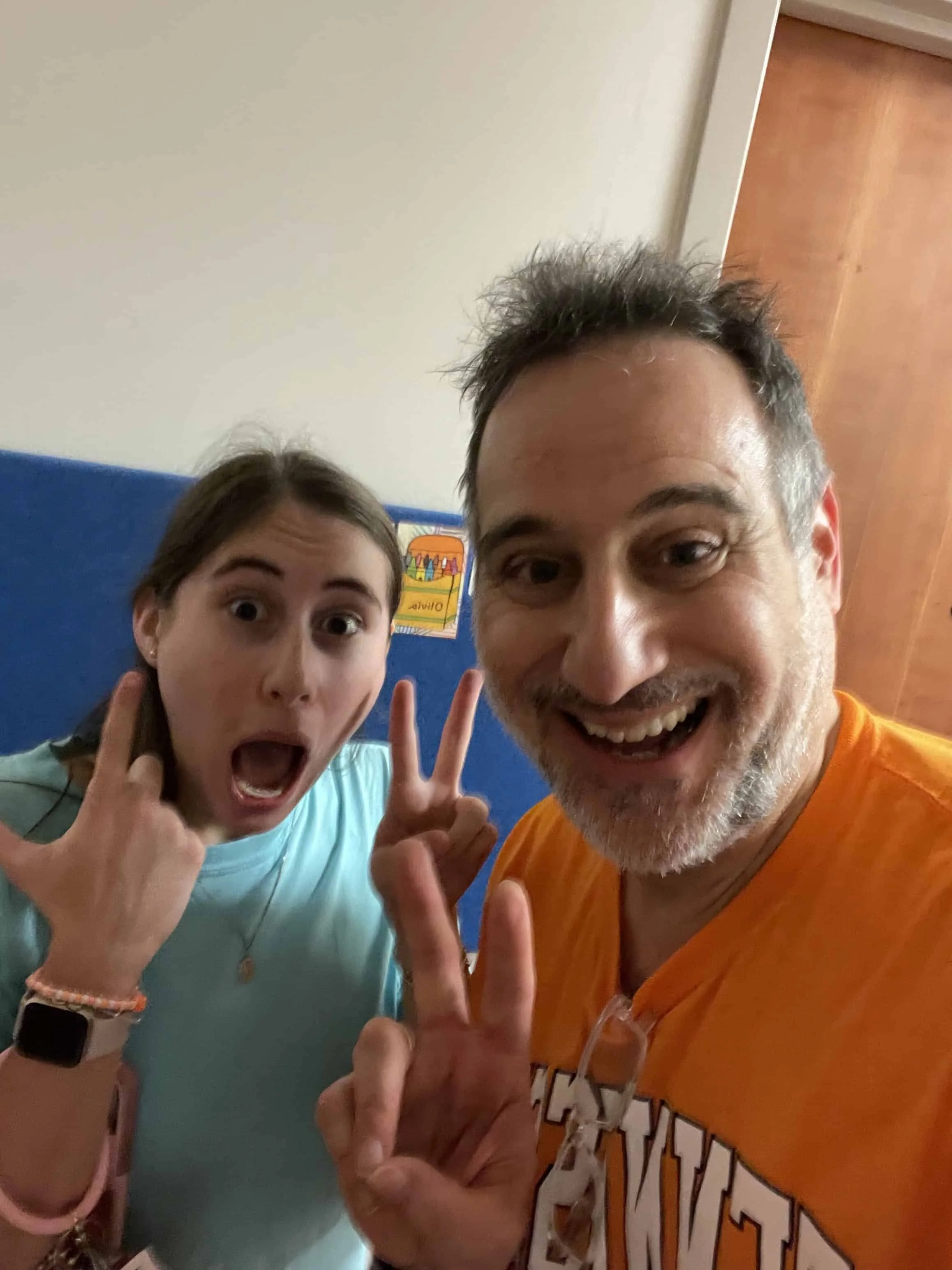 Father and his daughter making goofy faces together, flashing peace signs and playful hand gestures