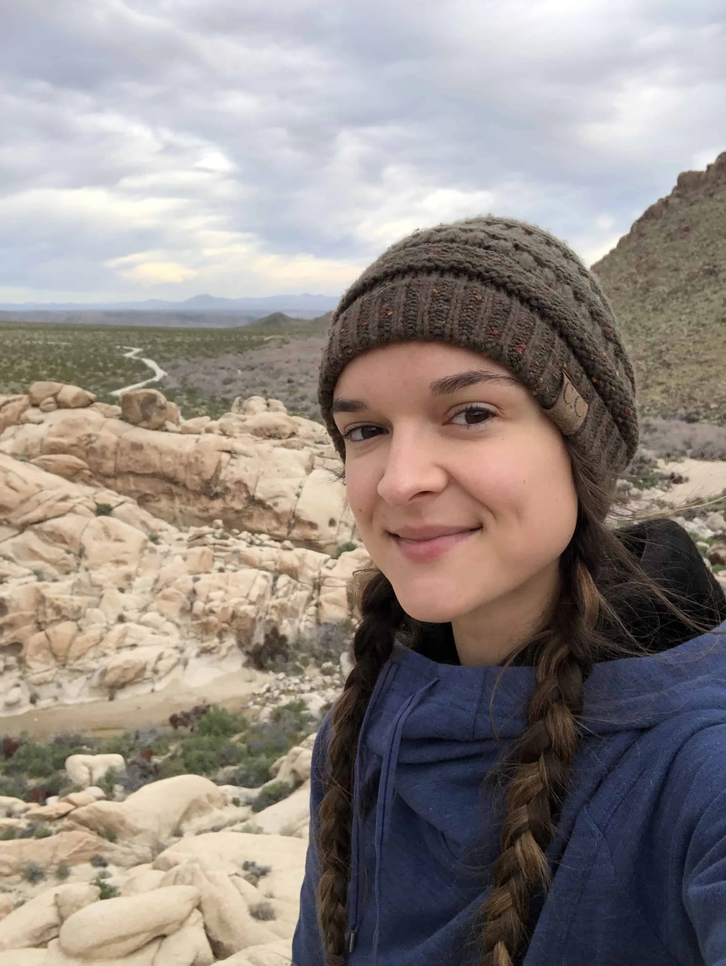 Woman hiking outdoors on a trail surrounded by nature.