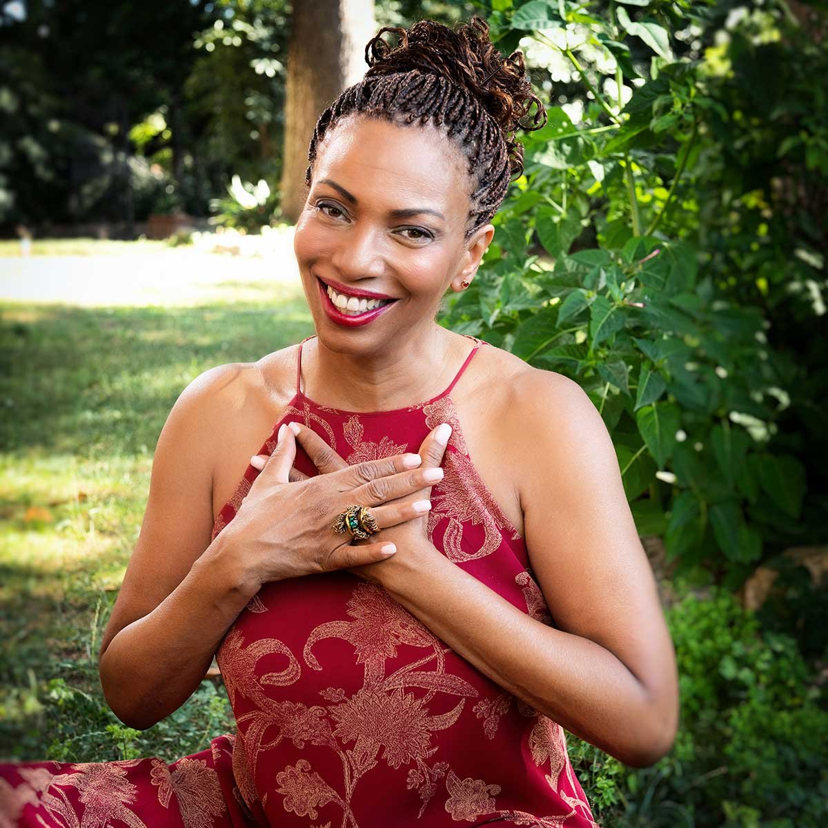 Smiling woman holds hands over her heart.