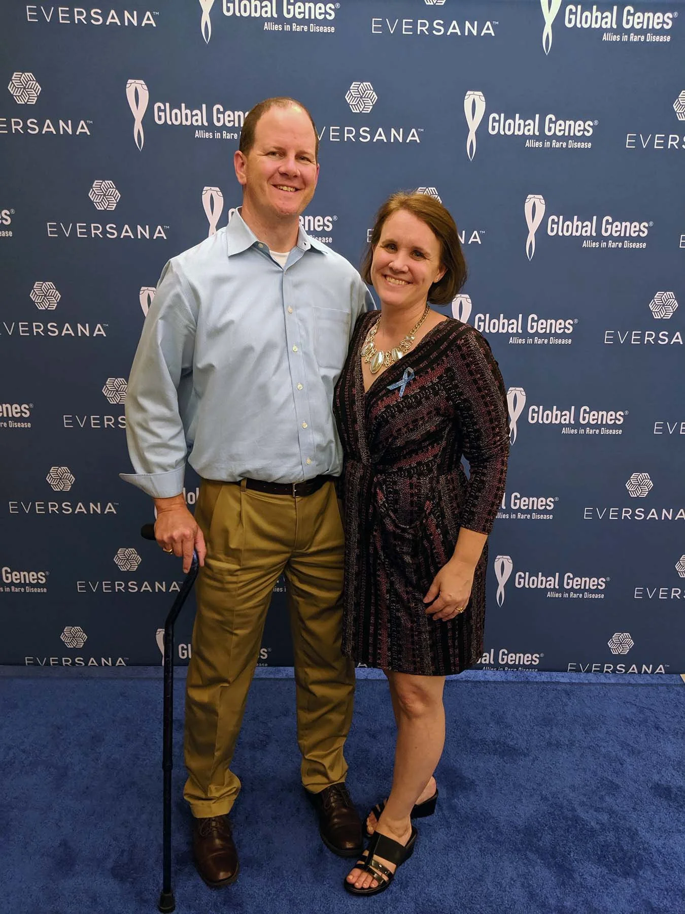 Couple posing at a rare disease advocacy conference in front of a Global Genes event backdrop.
