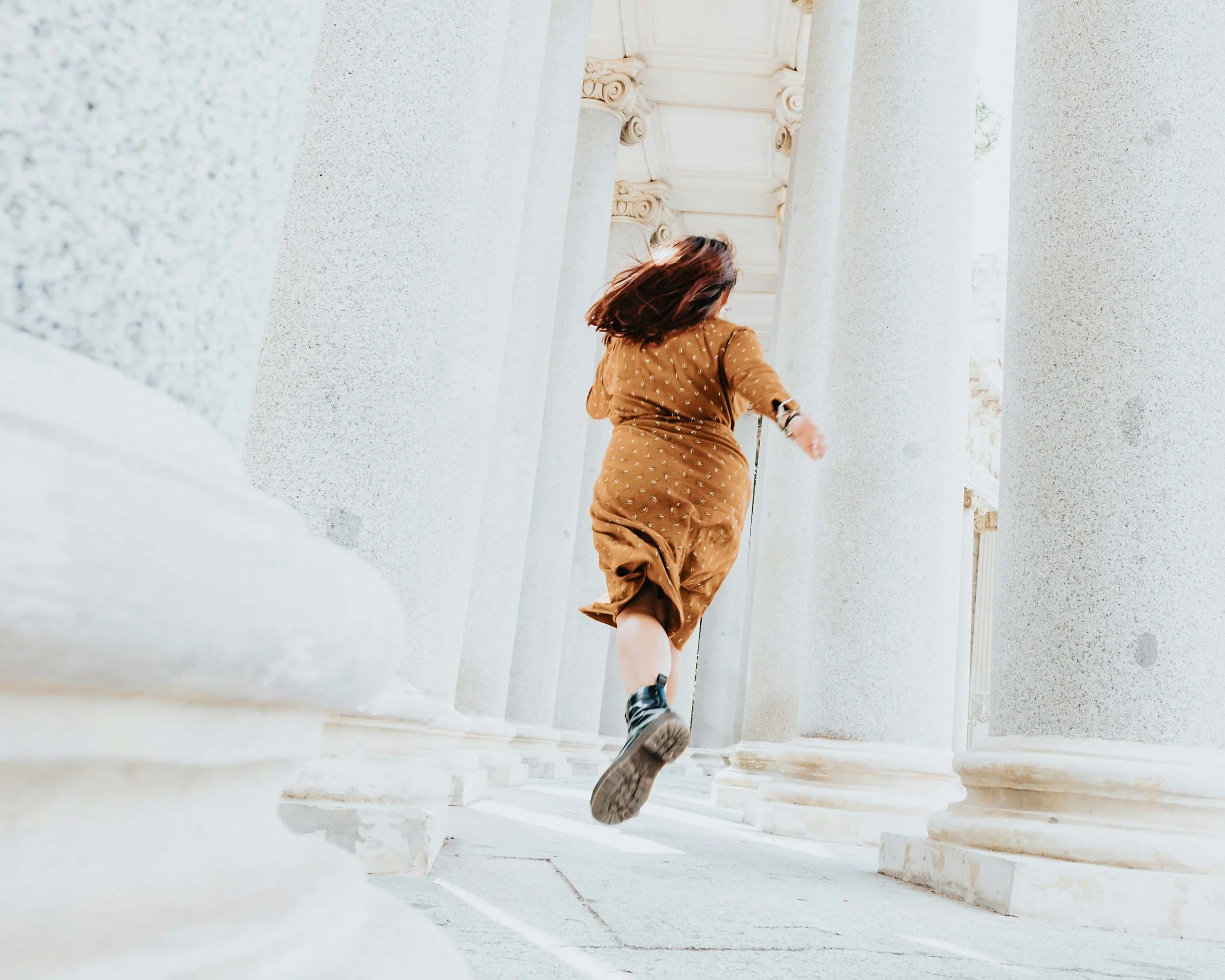 Woman walking between stone columns, symbolizing freedom and healing.