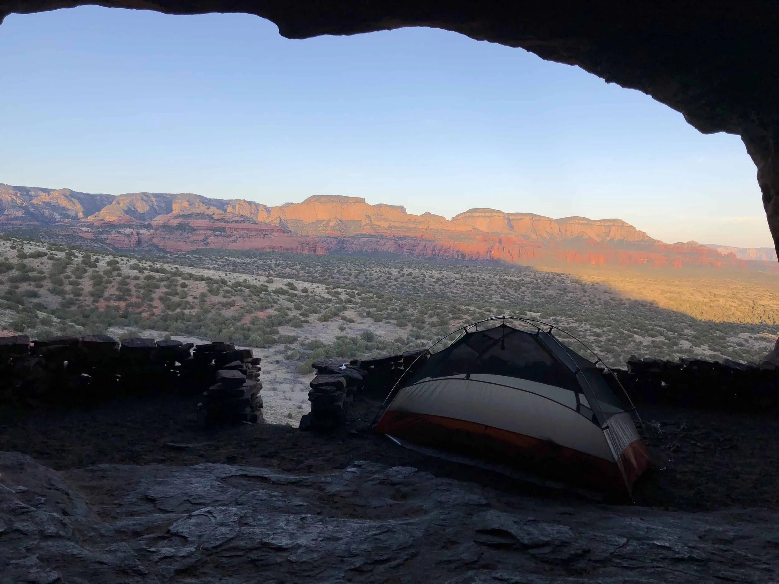 Tent set up in the Sedona desert surrounded by red rocks and desert landscape.
