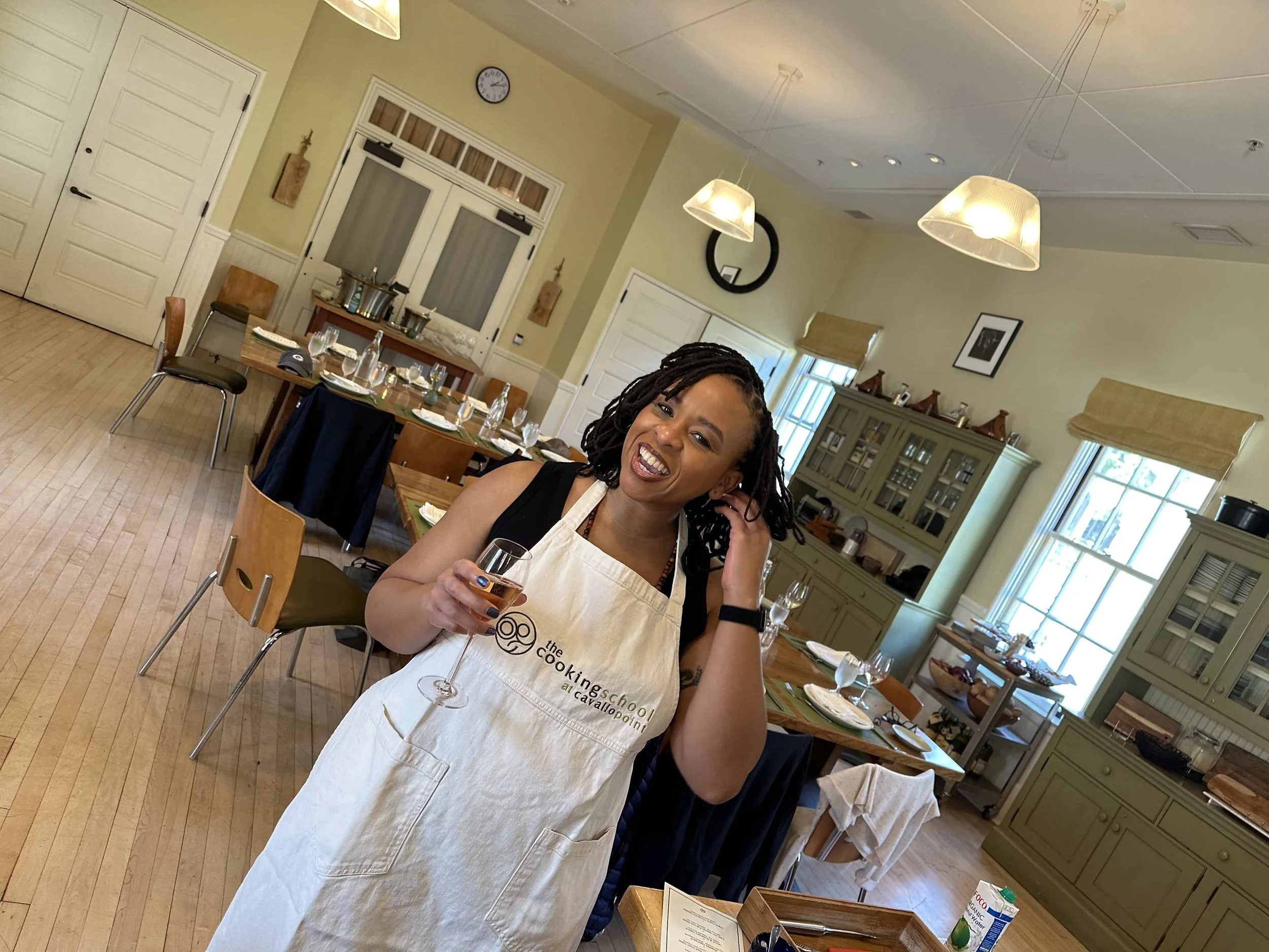 Happy woman holding a glass of wine in a cooking class.