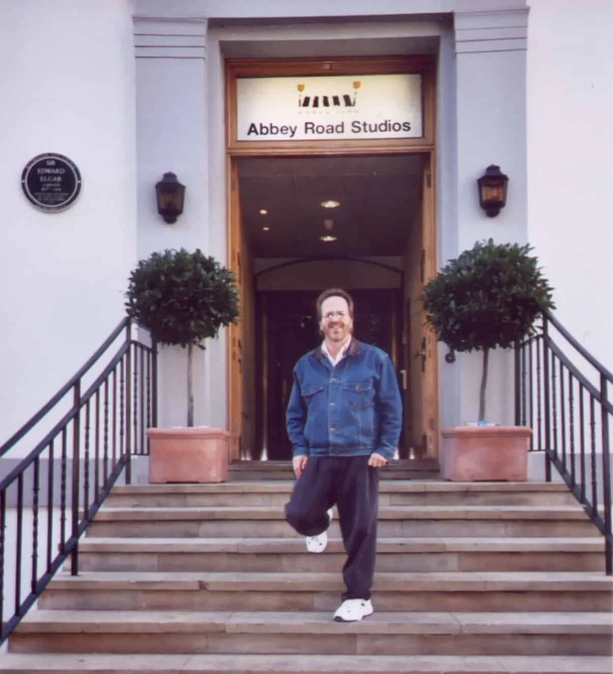 Man poses on the steps of Abbey Road Studios.