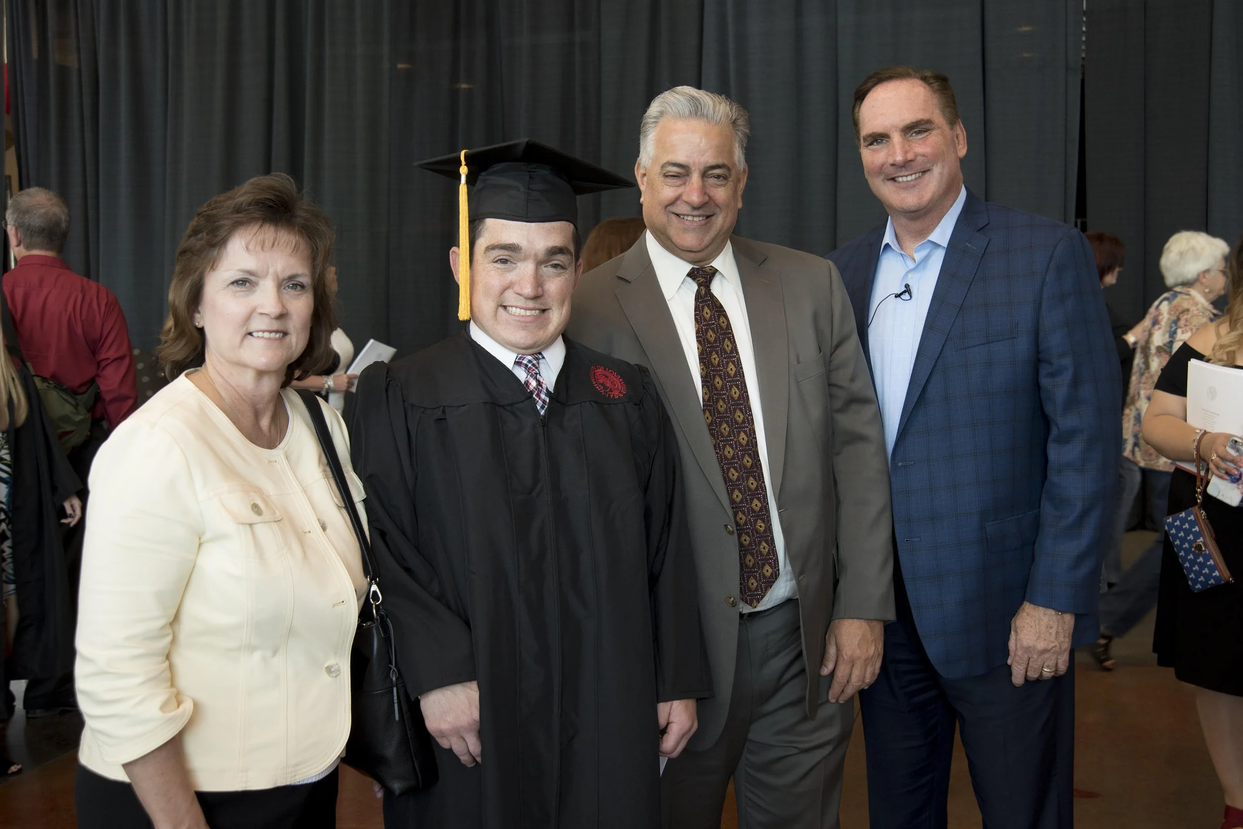 College graduate celebrating with family and supporters at a graduation ceremony.