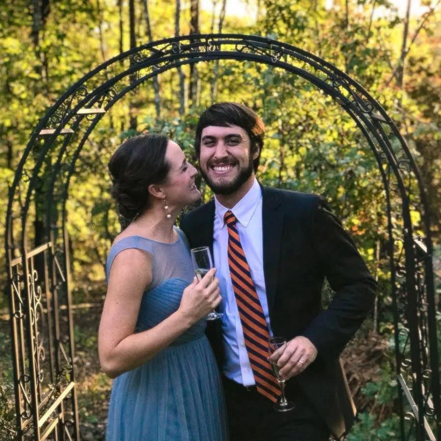 Couple smiling together outdoors after a wedding celebration.
