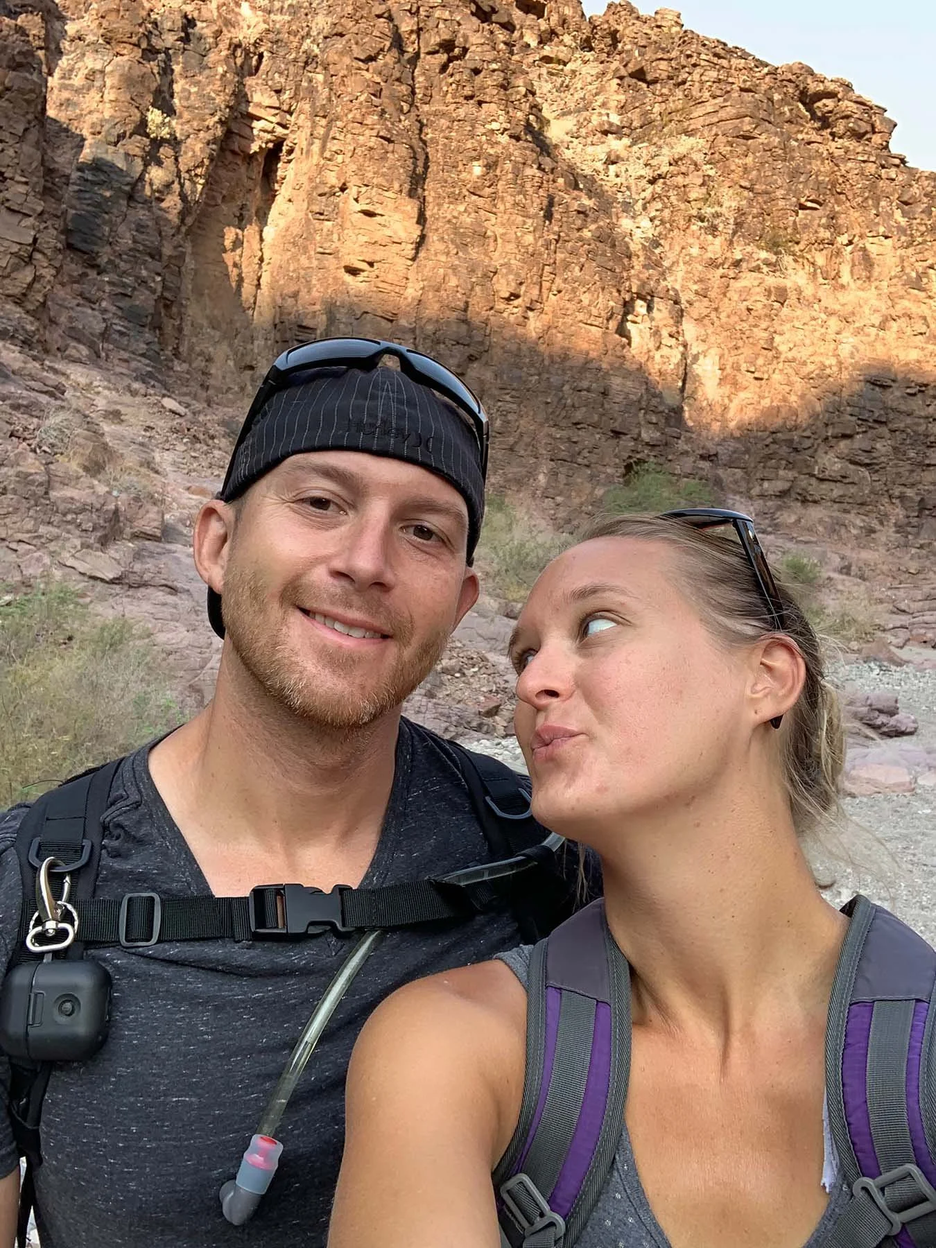 Couple posing together during a hike in a rocky canyon landscape.