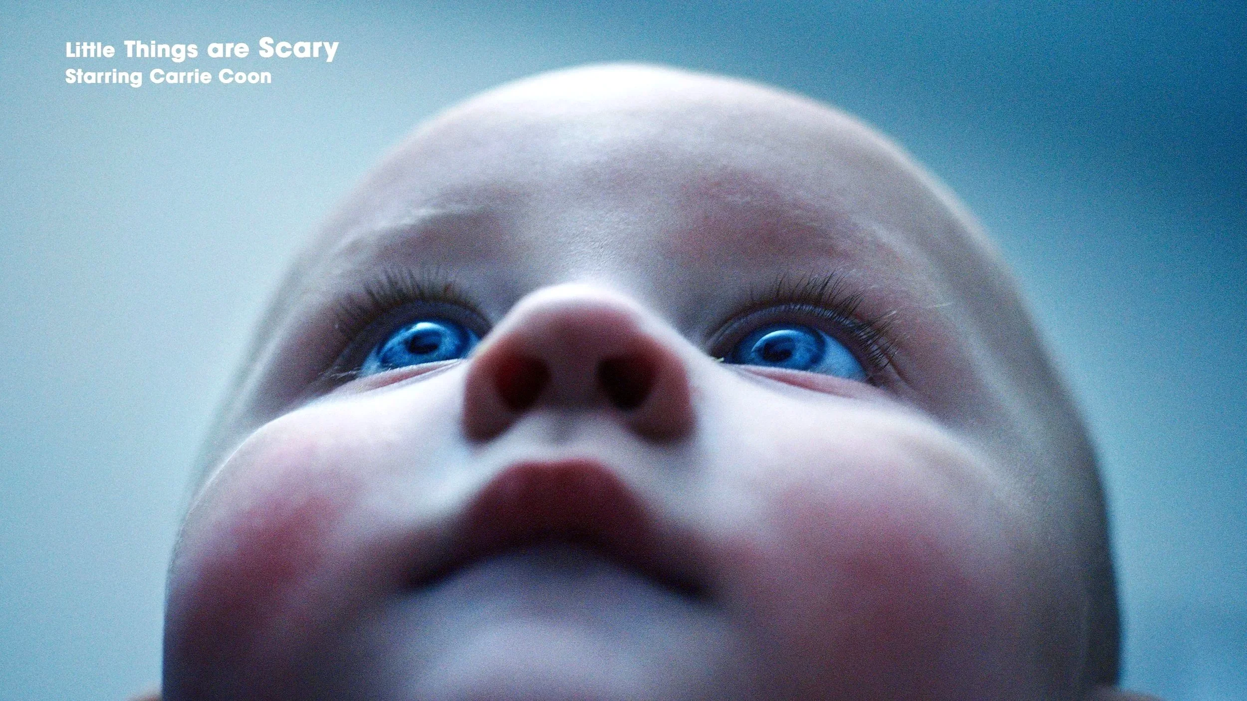 Close-up of a baby's face from below, showing blue eyes, a small nose, and chubby cheeks, against a light background. Text in the top left corner reads "Little Things are Scary" and "Starring Carrie Coon."