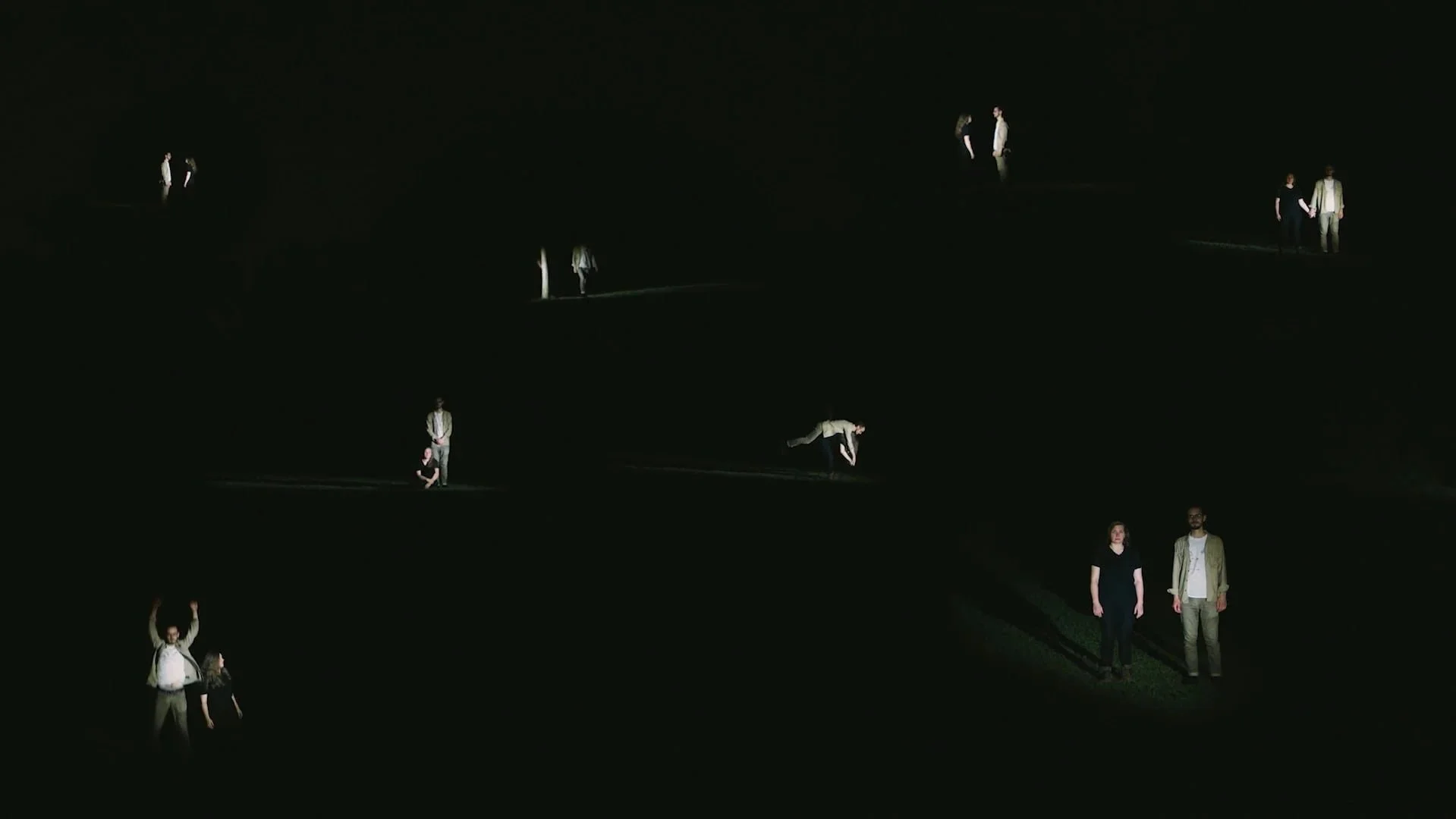 Multiple people illuminated in darkness, appearing as floating or walking on different levels in a vast, dark space.