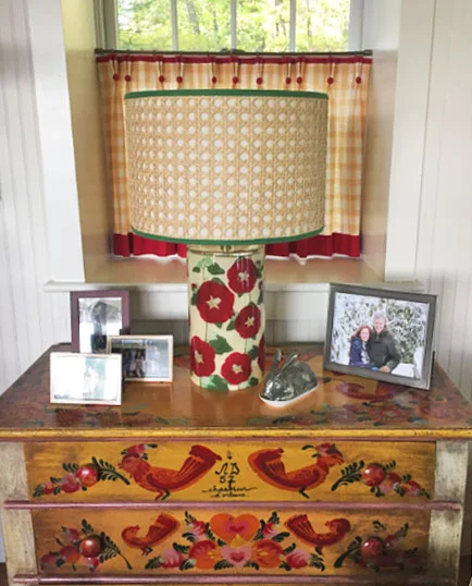 Gingham window treatments act as the backdrop for this unique chest of drawers.