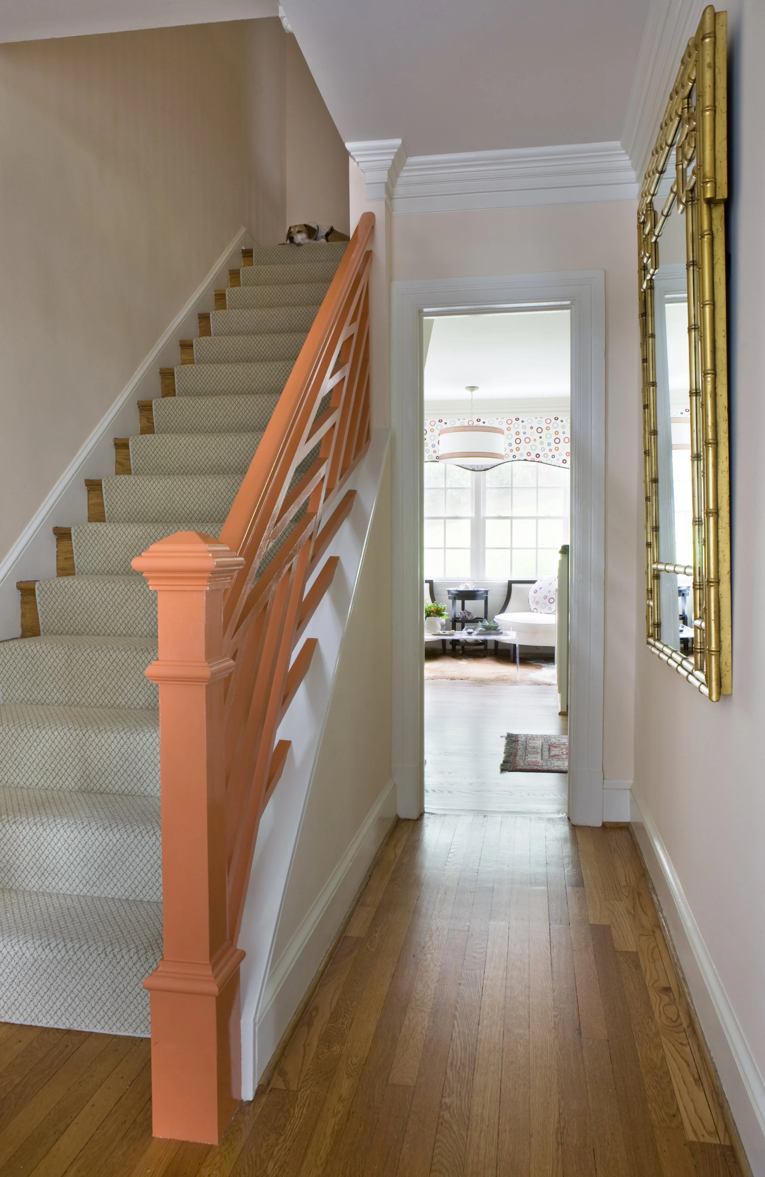 The custom light in the kitchen seating area pairs nicely with the custom railing painted coral in the foyer of this fun home.