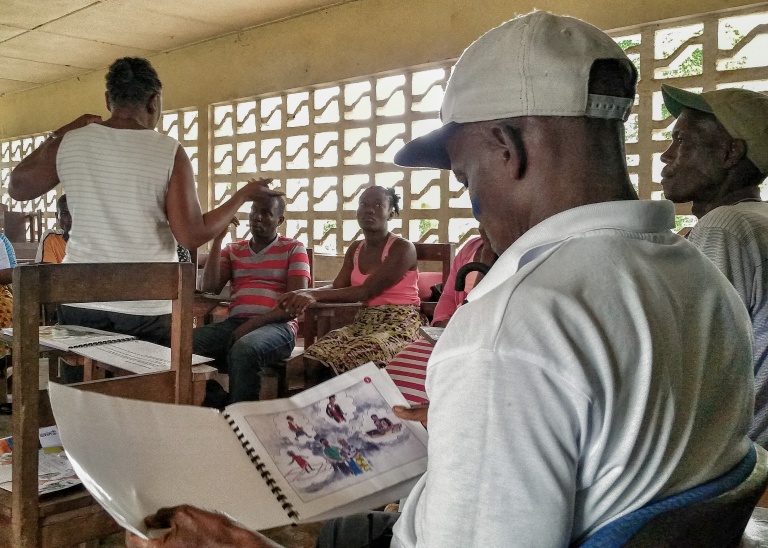  A participant reads through the Another Option Peer Education Guide during a community training.   