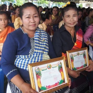 Mdm. Phavoun (left) and Mdm. Khamphet (right) display their certificates of recognition.
