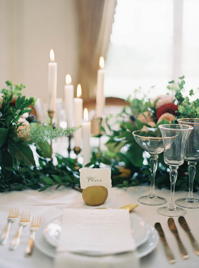 A table setting with candles and greenery at a French chateau wedding in Normandy.