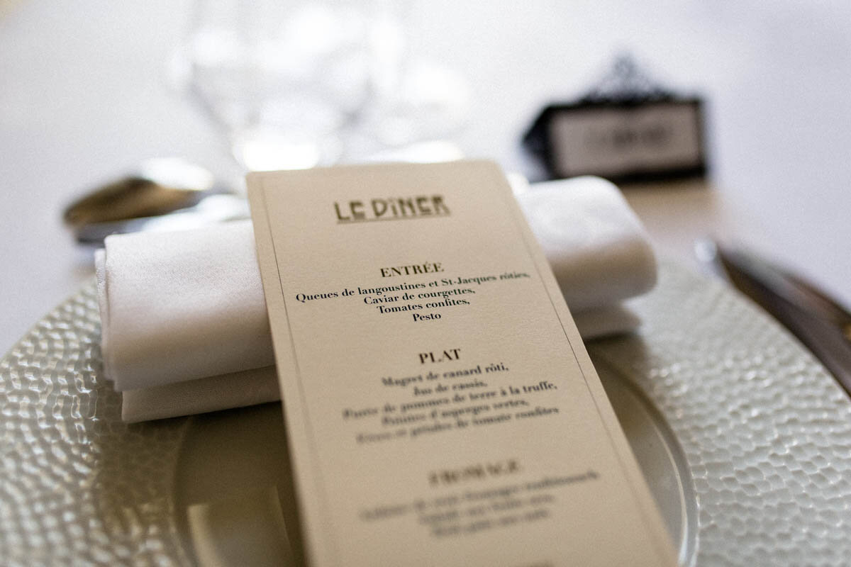 A table setting with a menu at a French chateau wedding.